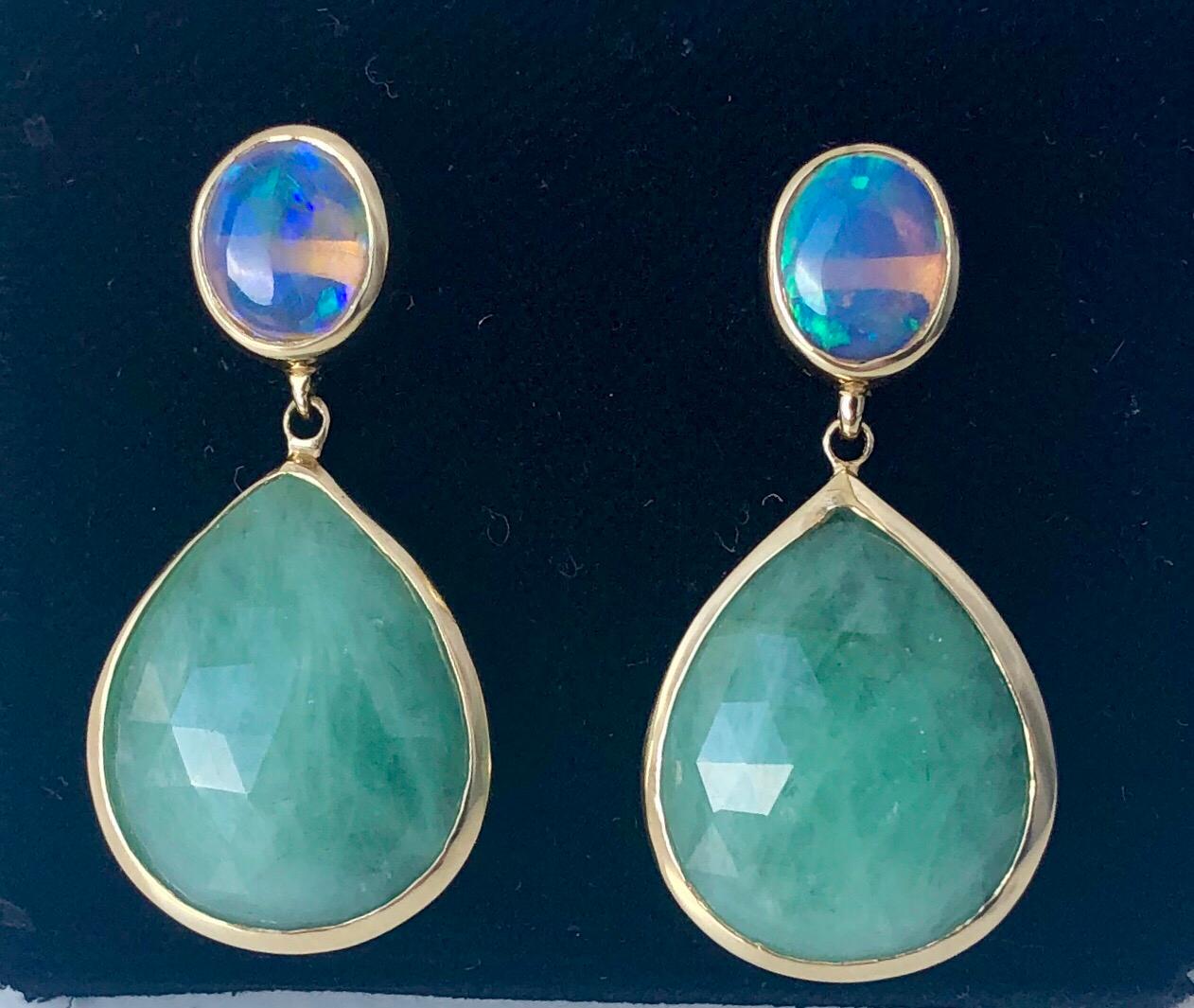 The bright Lightning Ridge crystal black opal has a clear, wide light spectrum that complements the kelly green of the rose-faceted emerald. Set in an 18 karat yellow gold. Model wearing piece before modified to pierced earring.  One of a kind.