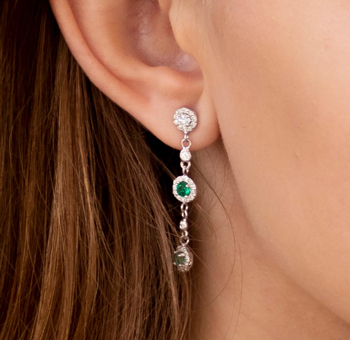 Fourteen karat white gold 1..75 inch drop earrings 
Diamond weighing 1.30 carat
Emeralds weighing 0.65 carat 
New Earrings
Handmade in USA
The 14 karat gold earrings are hanging off a post with push backs
Our design team select gemstones for their