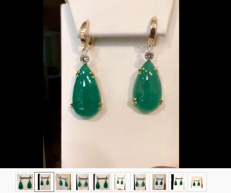 Stunning hanging earrings comprising of two pear cabochon-cut natural emeralds weighing 35.54 carats.  Excellent medium intense green color. The emeralds are certified by CDTEC stating that they are of Colombian origin with moderate clarity
