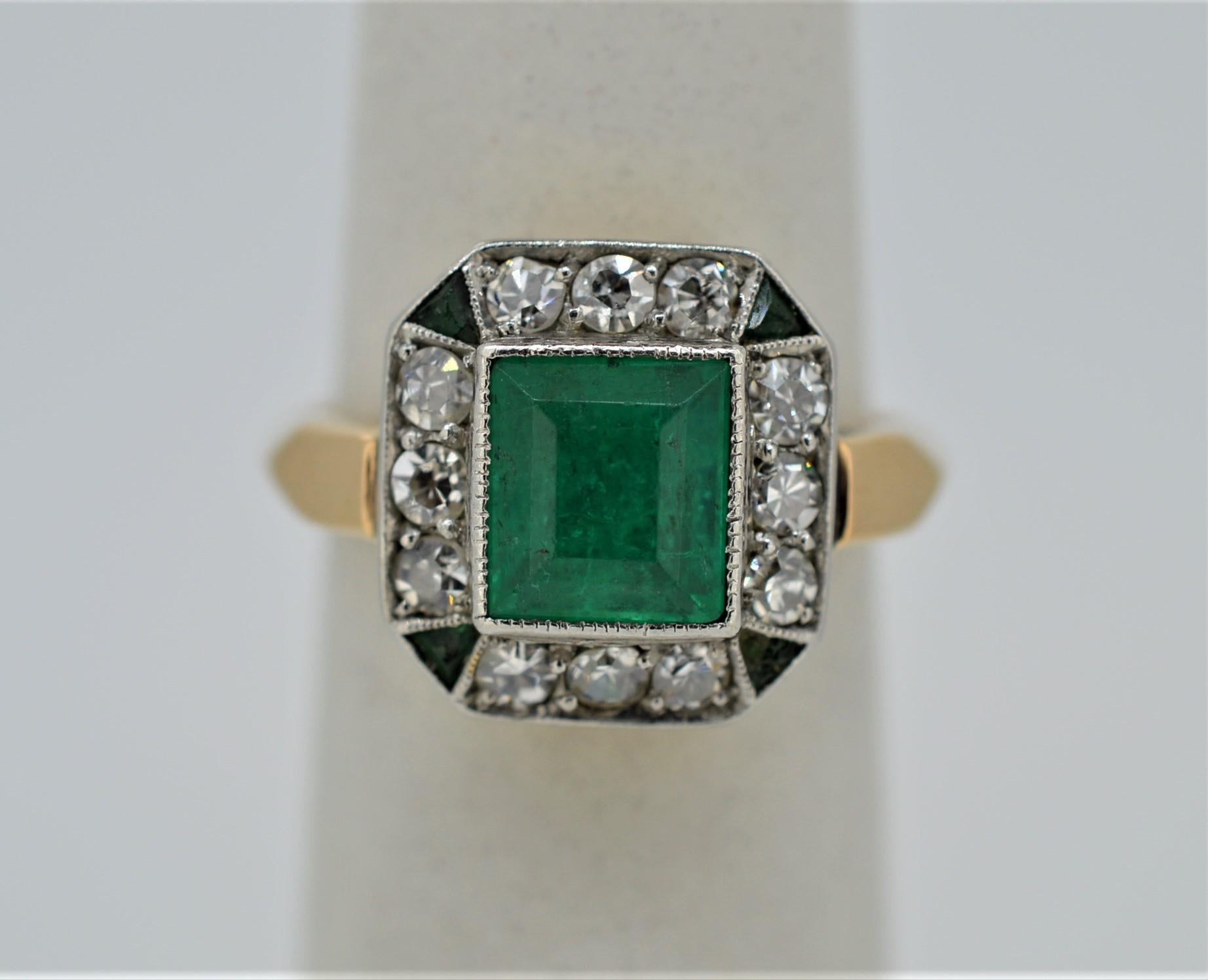 Elegant antique emerald and diamond fourteen karat yellow gold and platinum ring featuring a 1.25 carat soft green natural emerald center stone measuring 6.25 x 7.25 framed with 
twelve Miner's cut diamonds, H/SI2 when graded in the setting with an
