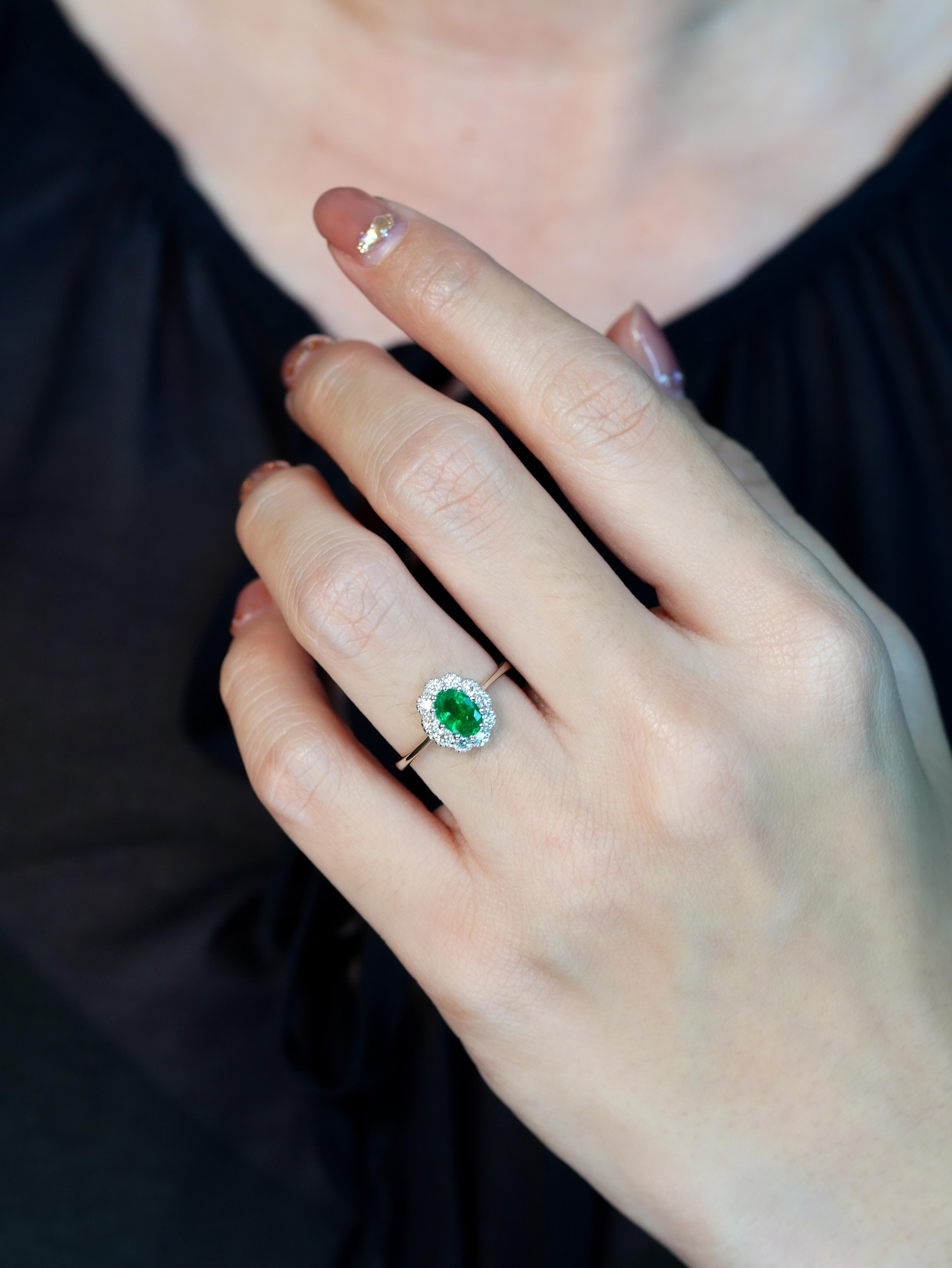 Mostrando un encanto antiguo, este anillo de compromiso tiene una esmeralda ovalada en su corazón, rodeada de un halo de diamantes engastados que amplifican su radiante belleza. El intrincado diseño resalta el intenso verde de la esmeralda, mientras