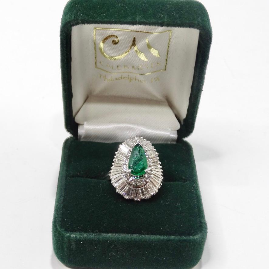 Embody the elegance of the 1970s with this ballerina style ring containing a center emerald surrounded by full cut diamonds and then surrounded by baguette diamonds. Featuring a beautiful pear shaped, medium dark H1 emerald as the focal point. The