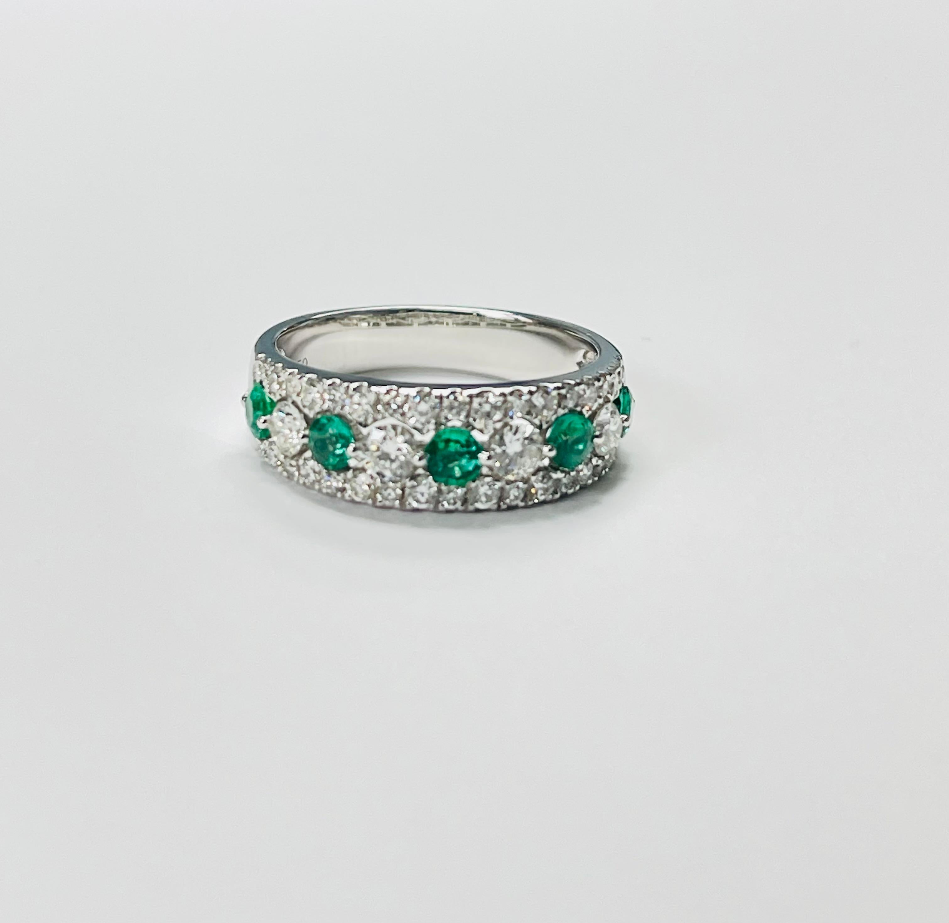 Emerald and Diamond band ring beautifully hand crafted in 18 karat white gold. 
The details are as follows: 

Emerald weight : 0.45 carat 
Diamond weight : 0.85 carat ( G color and VS clarity ) 
Gold: 18K 
Ring size : 6 1/4 

