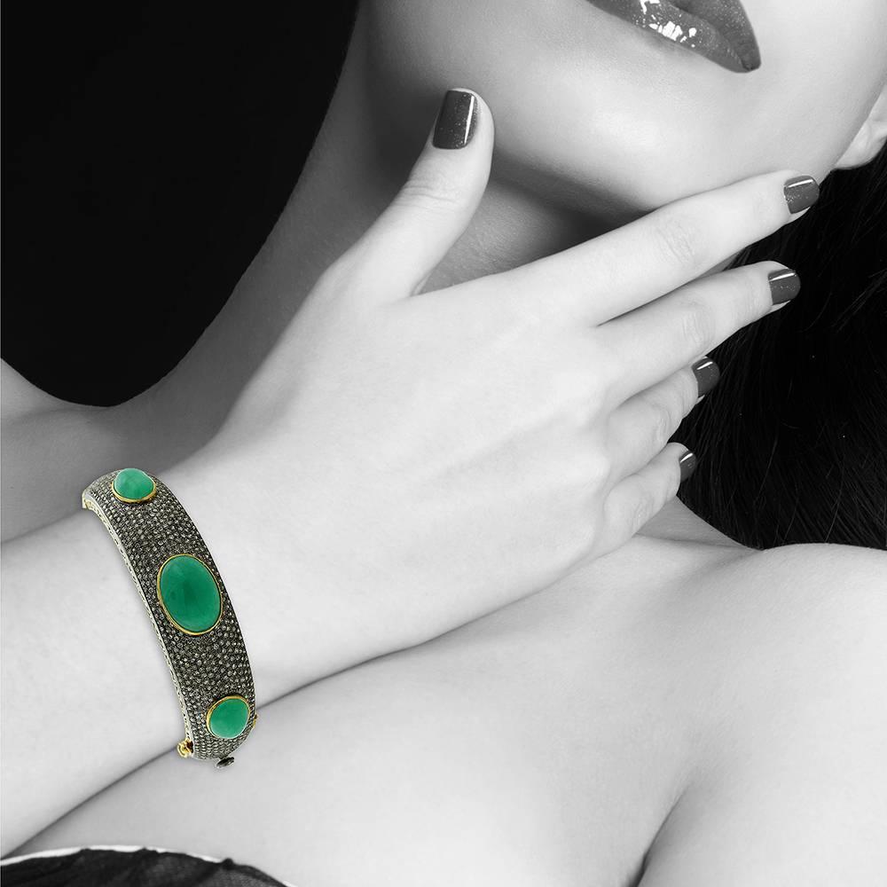 Ce bracelet rigide en diamant et émeraude cabochon de forme ovale d'aspect ancien est un délice.

Fermeture : S'ouvre sur le côté avec une fermeture de sécurité 