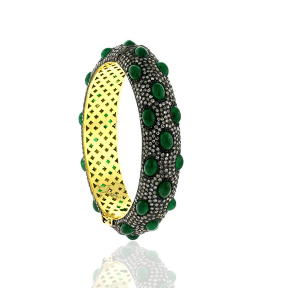 Chic and classy this cabochon emerald with pave diamonds bangle is oval in shape and opens on side and easy to wear on. This bangle has safety clasps on side.

14k: 8.35g
Diamond: 10.41ct
Emerald: 25.97 cts