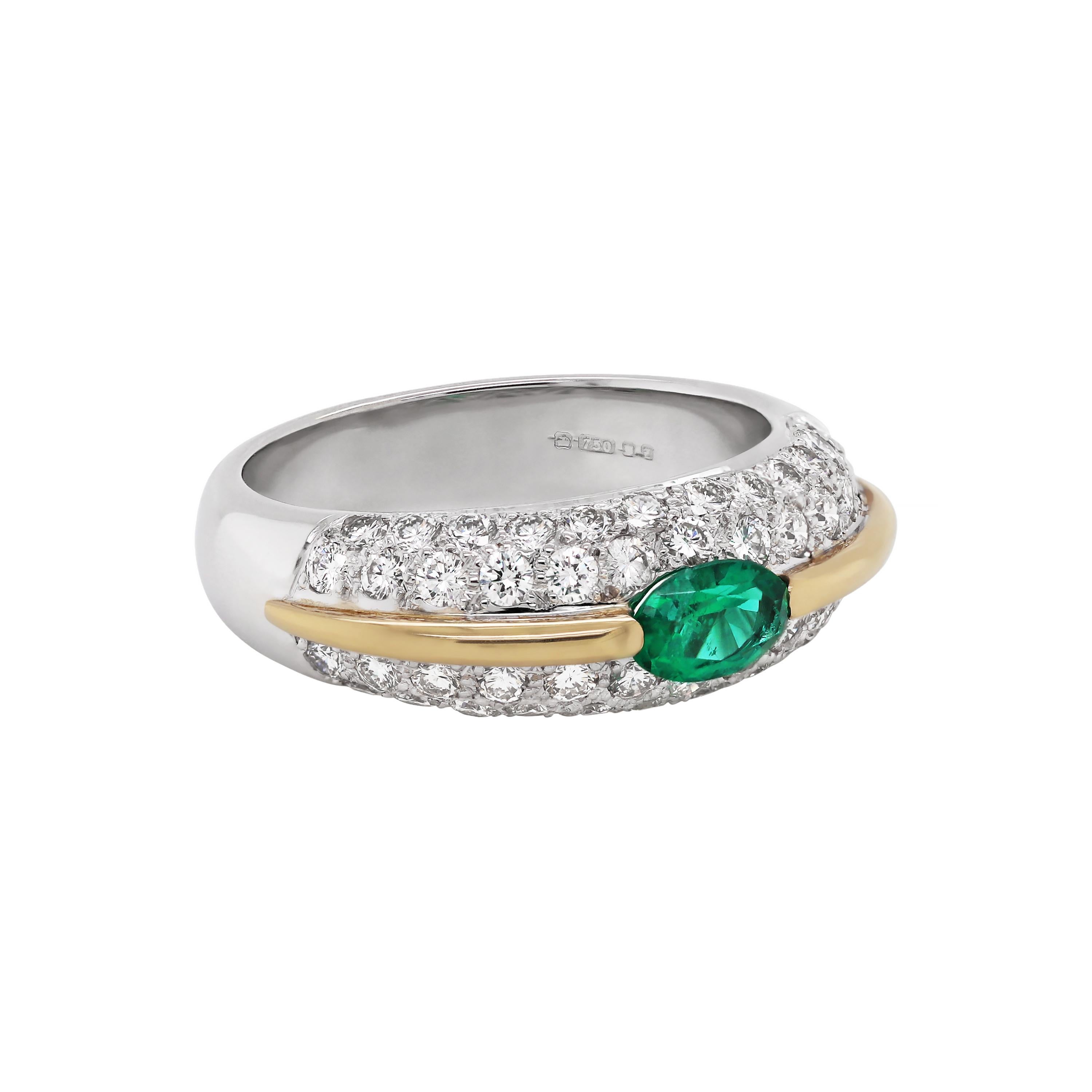 This contemporary small bombé cluster ring features a tension set oval emerald weighing 0.35ct in the center of a diamond pavé set mount. The ring is beautifully designed with a contrasting 18 carat yellow gold divide, set two rows of round