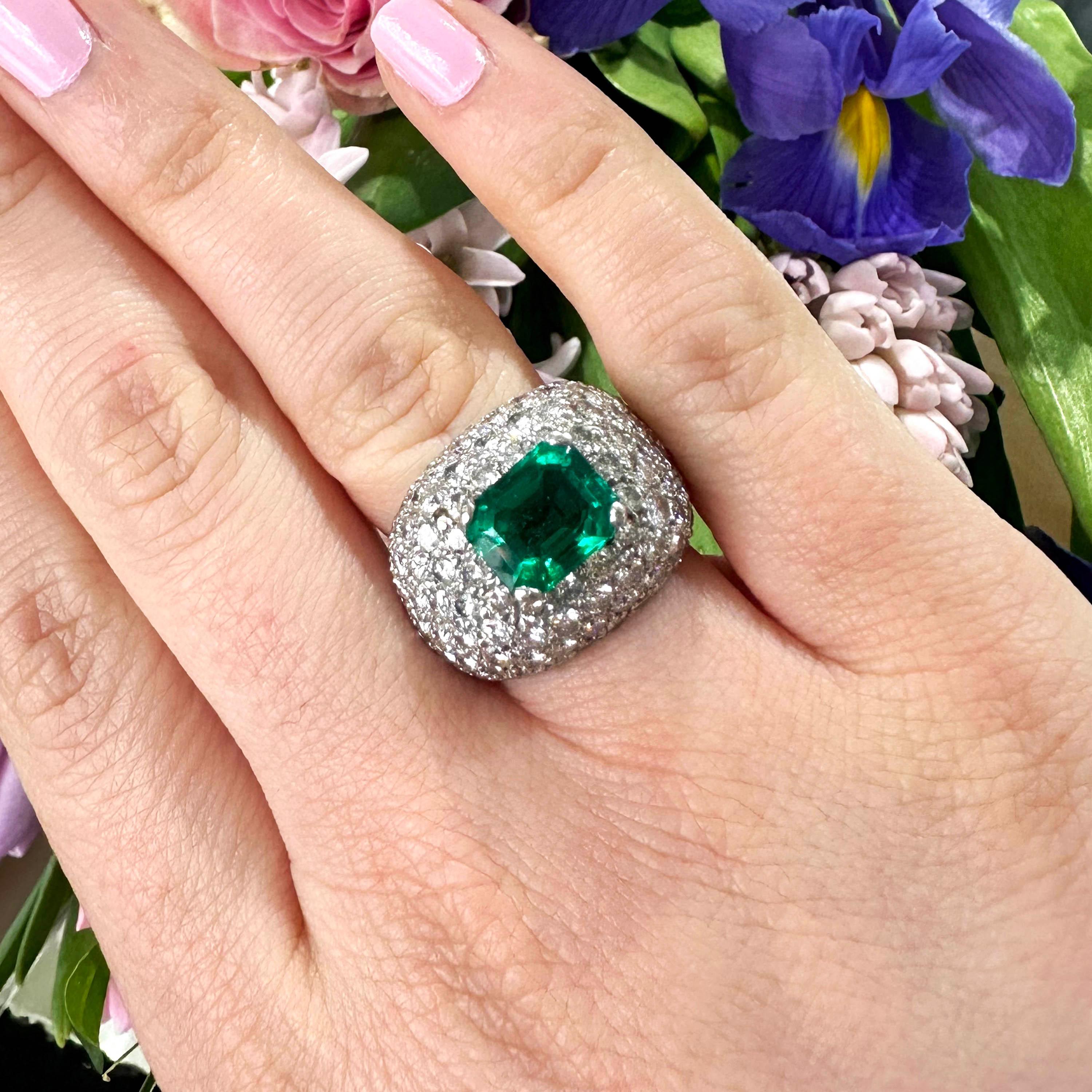 Ein moderner Ring mit Smaragd und Diamanten im Fancy-Bombé-Stil, in der Mitte mit einem Smaragd im Smaragdschliff besetzt, mit einem geschätzten Gewicht von 2,40 Karat, umgeben von Diamanten im Brillantschliff in einer Pavé-Fassung, mit einem