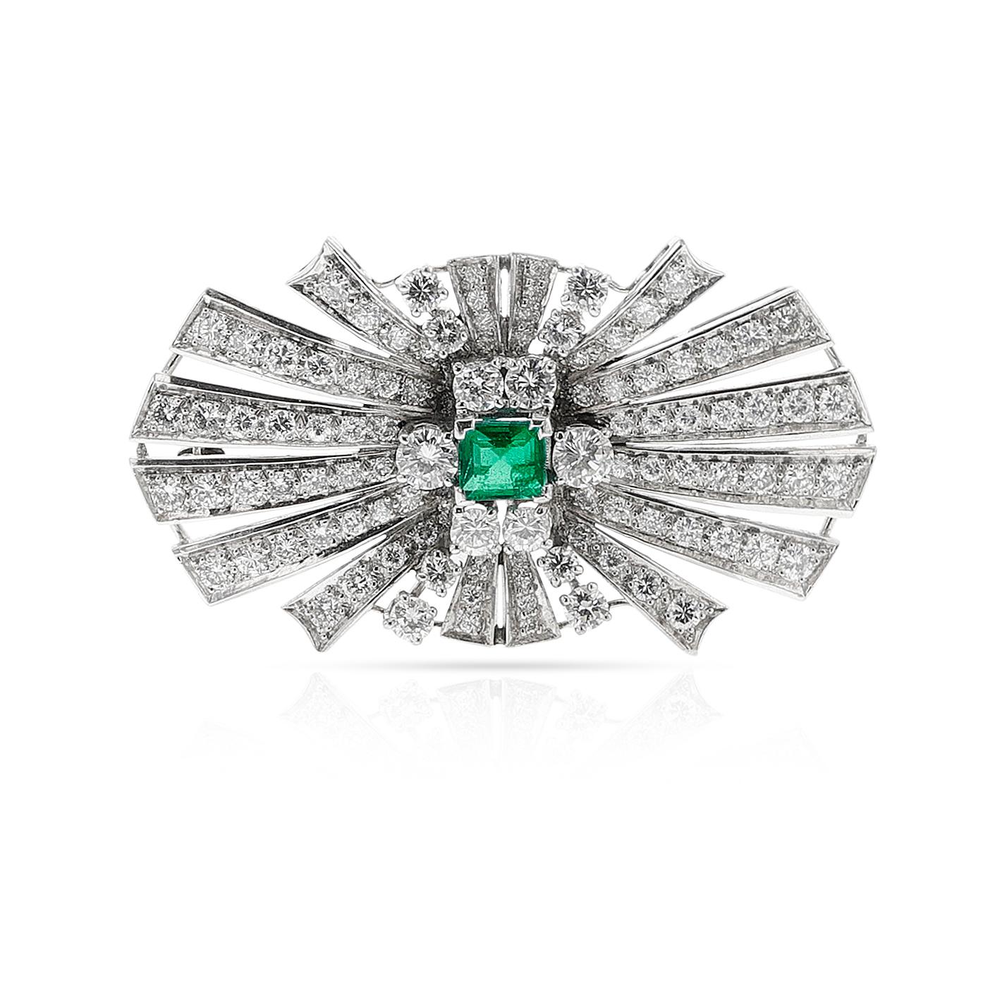 An Emerald and Diamond Bow Brooch made in Platinum. Set with a square emerald, weighing appx. 0.60 carats and round diamonds appx. 4 carats. The length is 1 3/4 inches. The brooch is made in platinum. The diamonds are estimated H-I color, VS