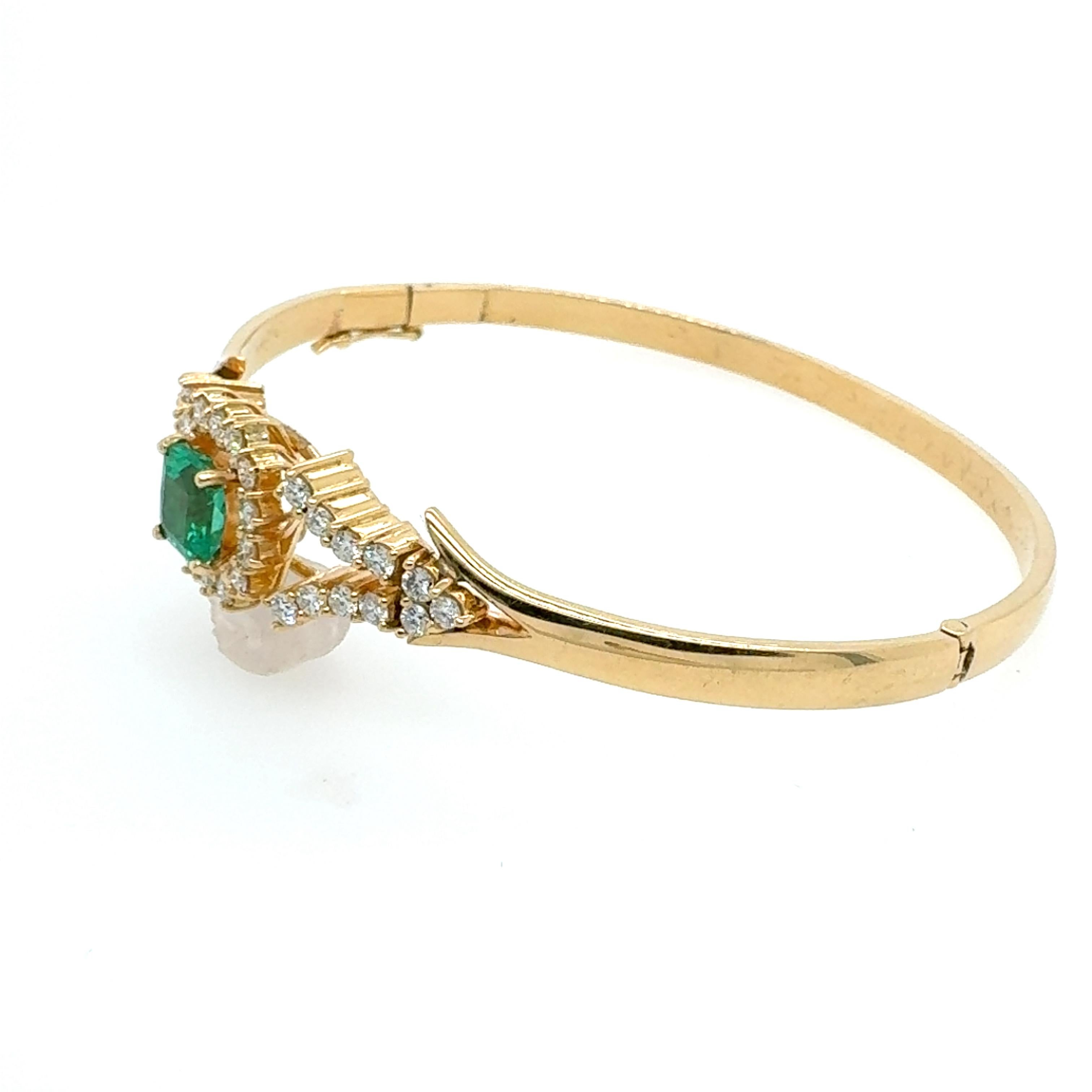Indulge in the luxurious allure of this contemporary Emerald and Diamond Bracelet, a stunning statement piece that effortlessly merges modern design with classic elegance. At its center is a brilliant Colombian emerald, weighing approximately 1.11