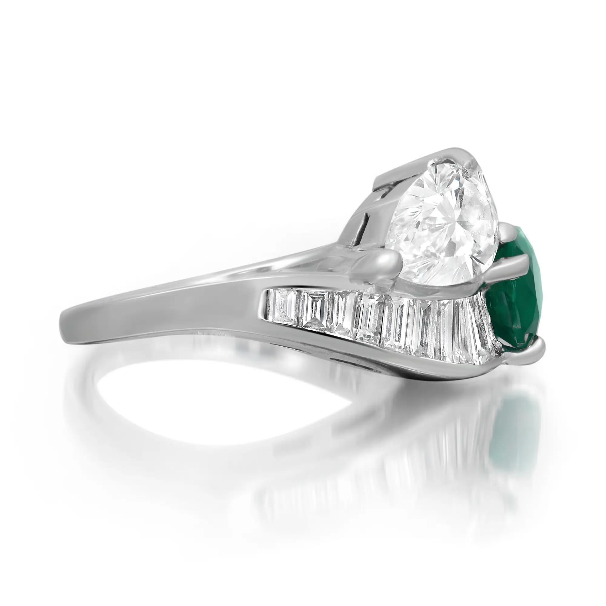 This stunning bypass ring is crafted in fine 18K white gold. Adorned with prong set shimmering pear cut emerald and diamond with channel set baguette cut diamonds on the band shoulders. Total emerald weight: 1.10 carats. Total diamond weight: 1