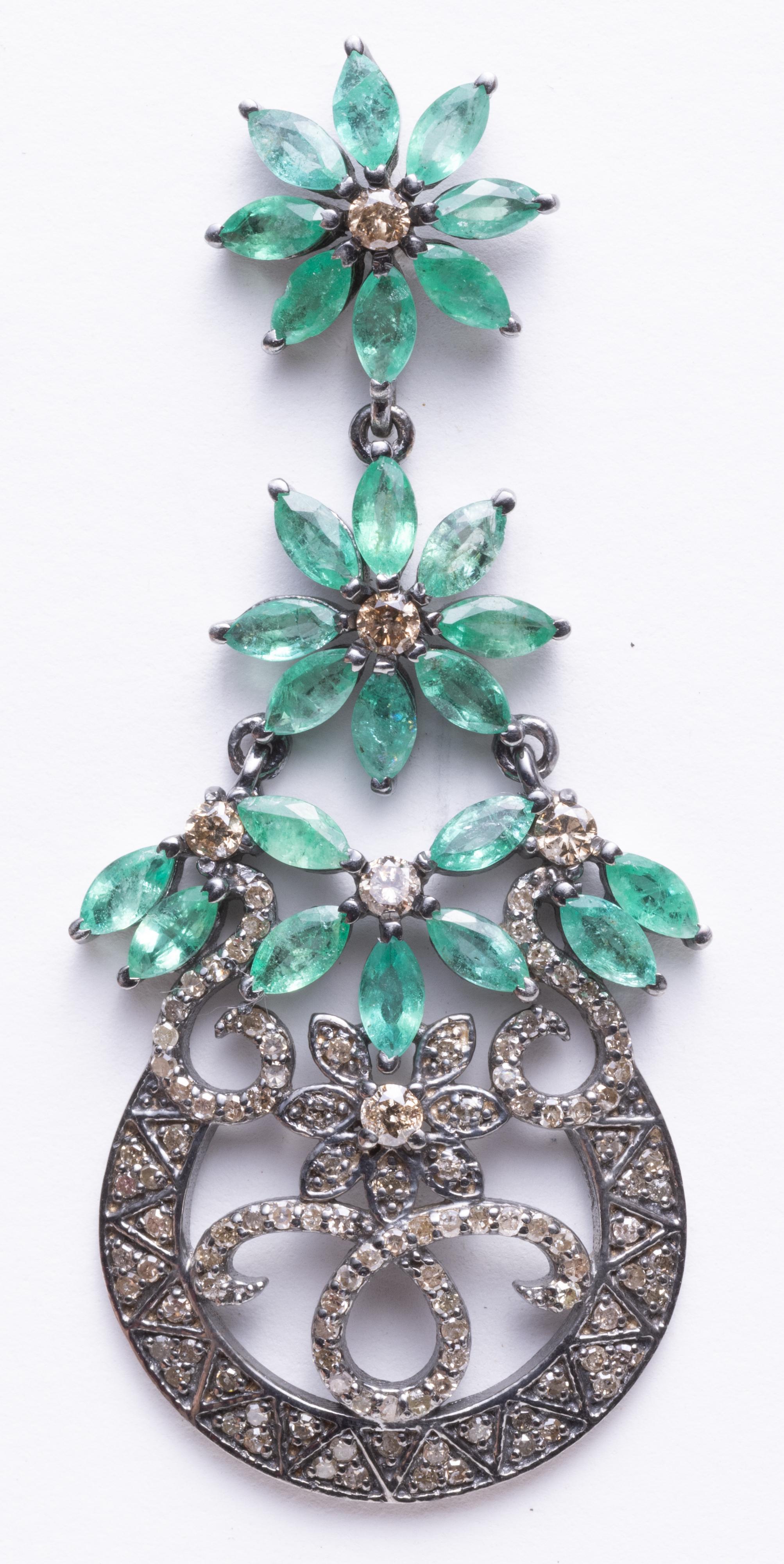 A stunning pair of chandelier earrings with marquise cut emeralds creating a flower pattern with a center round diamond at each flower.  The lower portion is a multitude of round, brilliant cut diamonds in a pave` setting.  Set in sterling silver