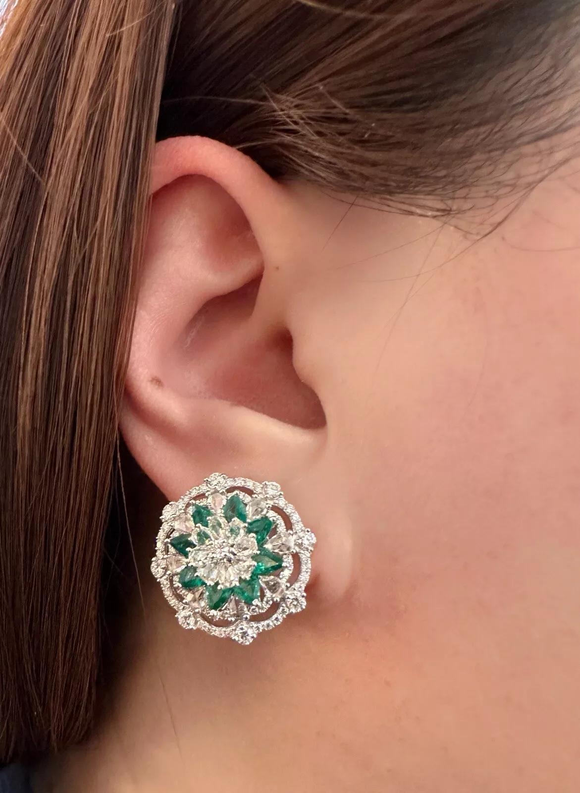 Boucles d'oreilles bouton fleur en or blanc 18 carats avec émeraudes et diamants.

Les boucles d'oreilles en diamant et émeraude présentent des diamants ronds et en forme de poire taillés en rose, ainsi qu'une rangée d'émeraudes en forme de poire