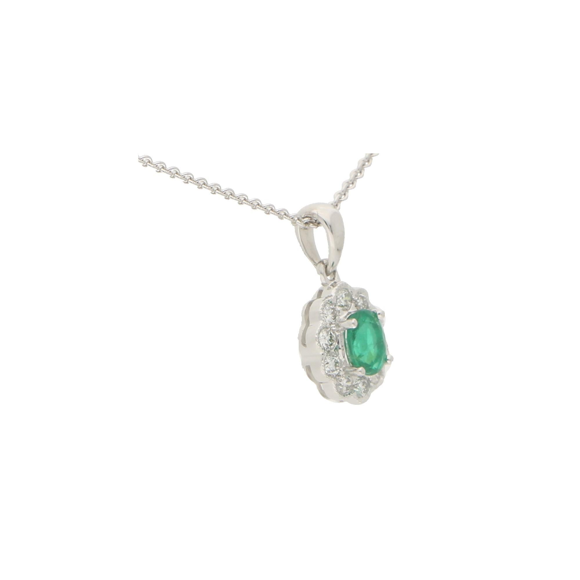 A beautiful emerald and diamond cluster pendant set in 18k white gold.

The pendant is centrally set with a vibrant green coloured oval cut emerald which is surrounded by 10 sparkly round brilliant cut diamonds. The pendant hangs from a white gold
