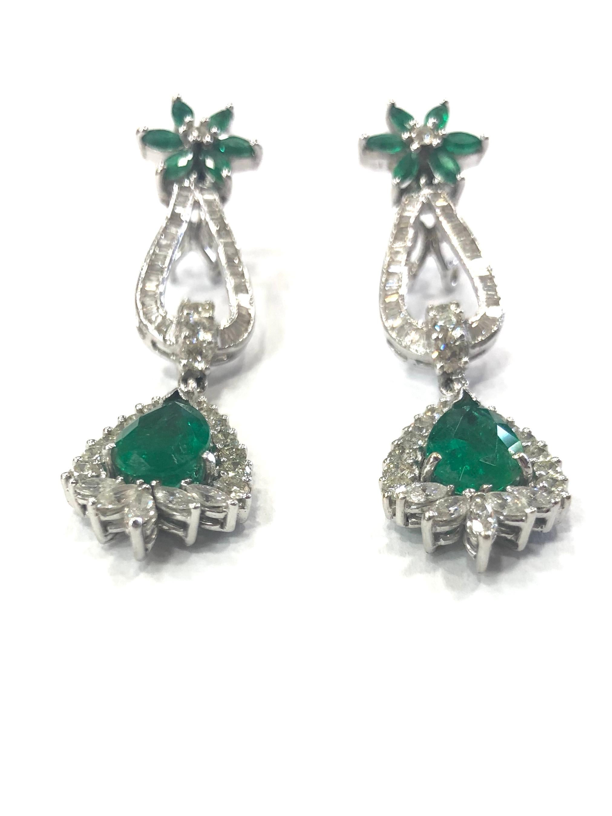 Fine Quality 1970s Emerald and Diamond Drop Earrings, set in 18ct white gold. Set with a large pear shape natural Emerald drop surrounded by fine round brilliant cut Diamonds, marquise shape Diamonds and baguette Diamonds with a further cluster of