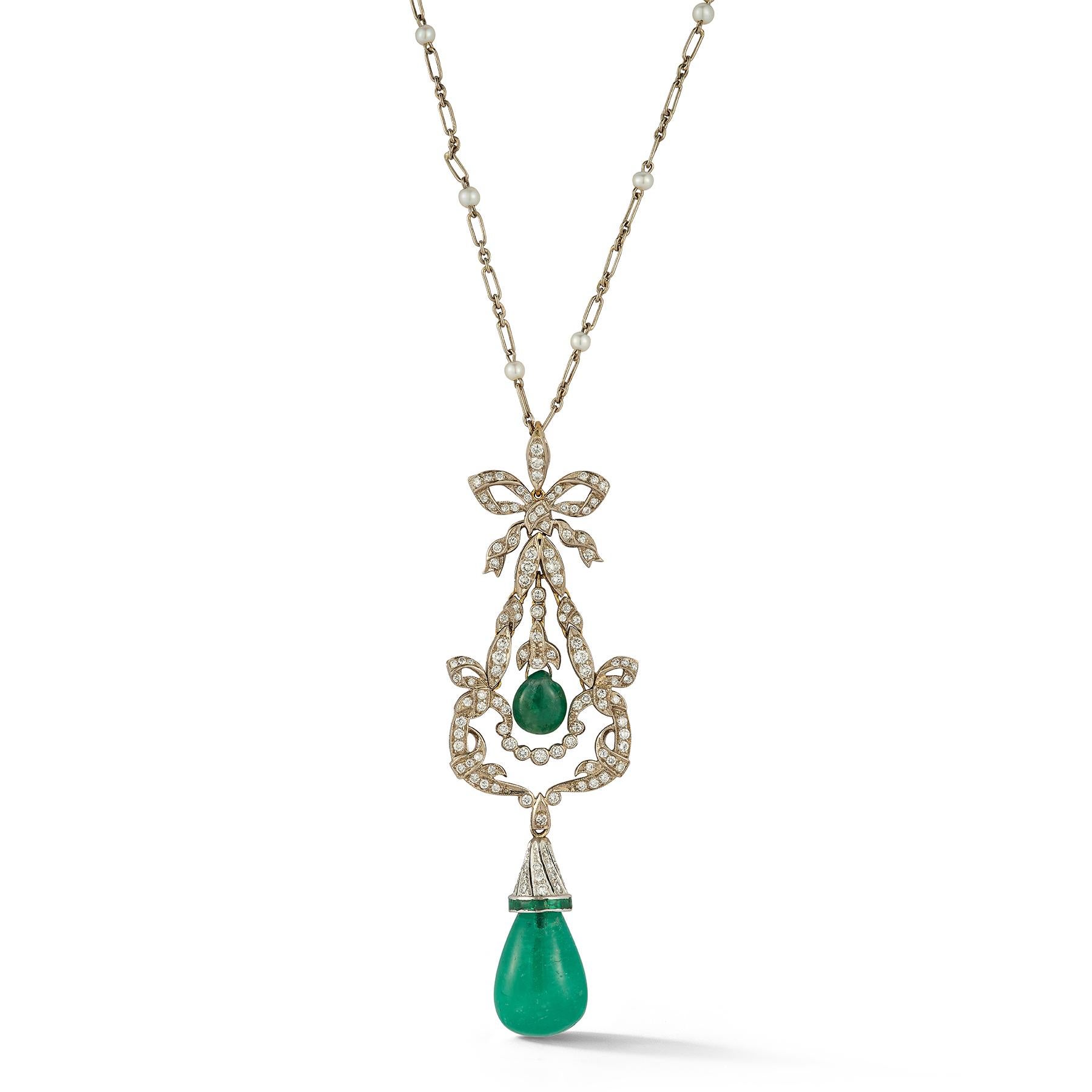 Emerald and Diamond Drop Pendant Necklace

Description:
A refined pendant necklace crafted in 18 karat white gold, set with luminous diamonds, pearls, and richly hued emeralds. The pendant features a delicate bow motif suspending two cabochon