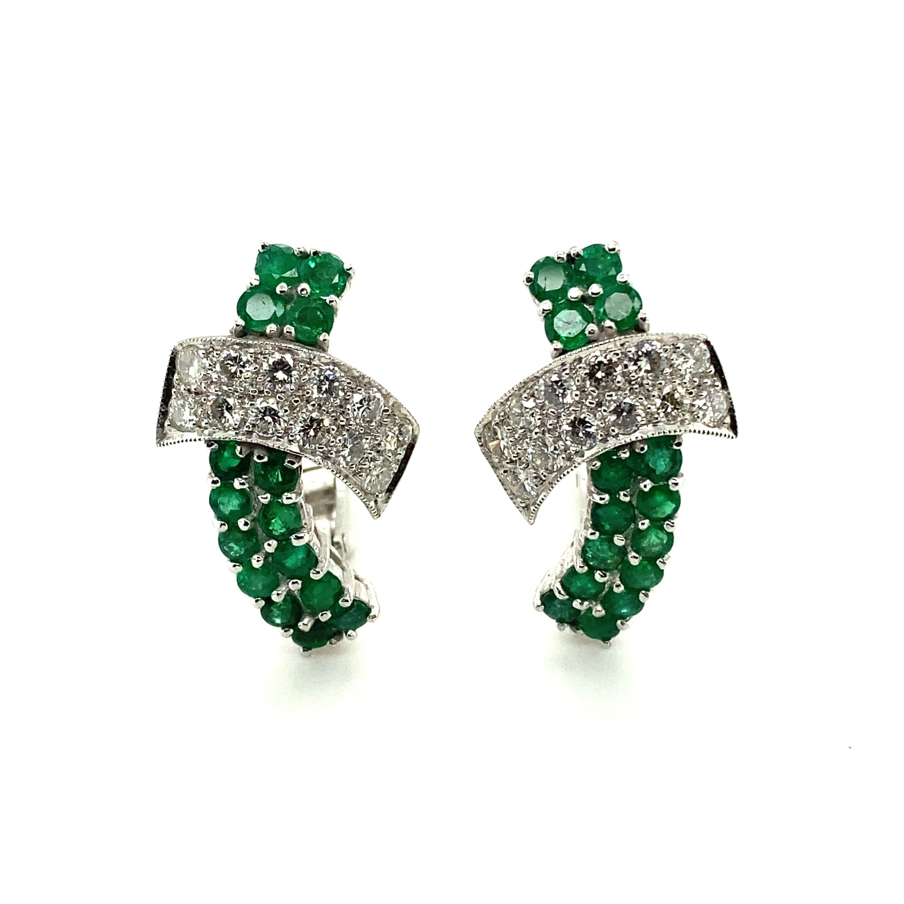 This pair of plafully t-shaped earclips in 18 karat white gold is set with 30 round-cut emeralds with a total weight of approximately 2.20 carats and 24 brilliant-cut diamonds of F/G colour and vs/si clarity with a total weight of approximately 1.44