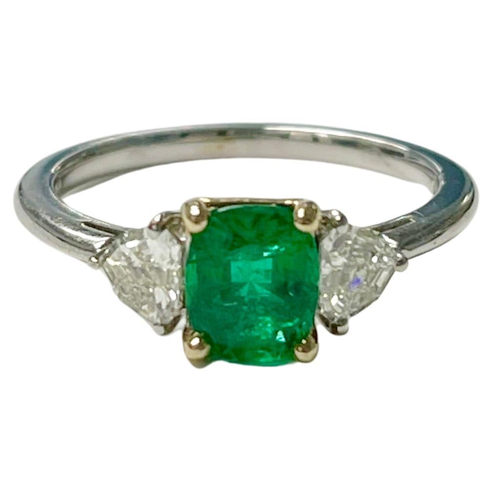 Emerald and trillion diamond engagement ring in handcrafted in 18k white gold. 
The details are as follows : 
Emerald weight : 0.90 carat 
Diamond weight : 0.42 carat 
Metal : 18k white gold 


