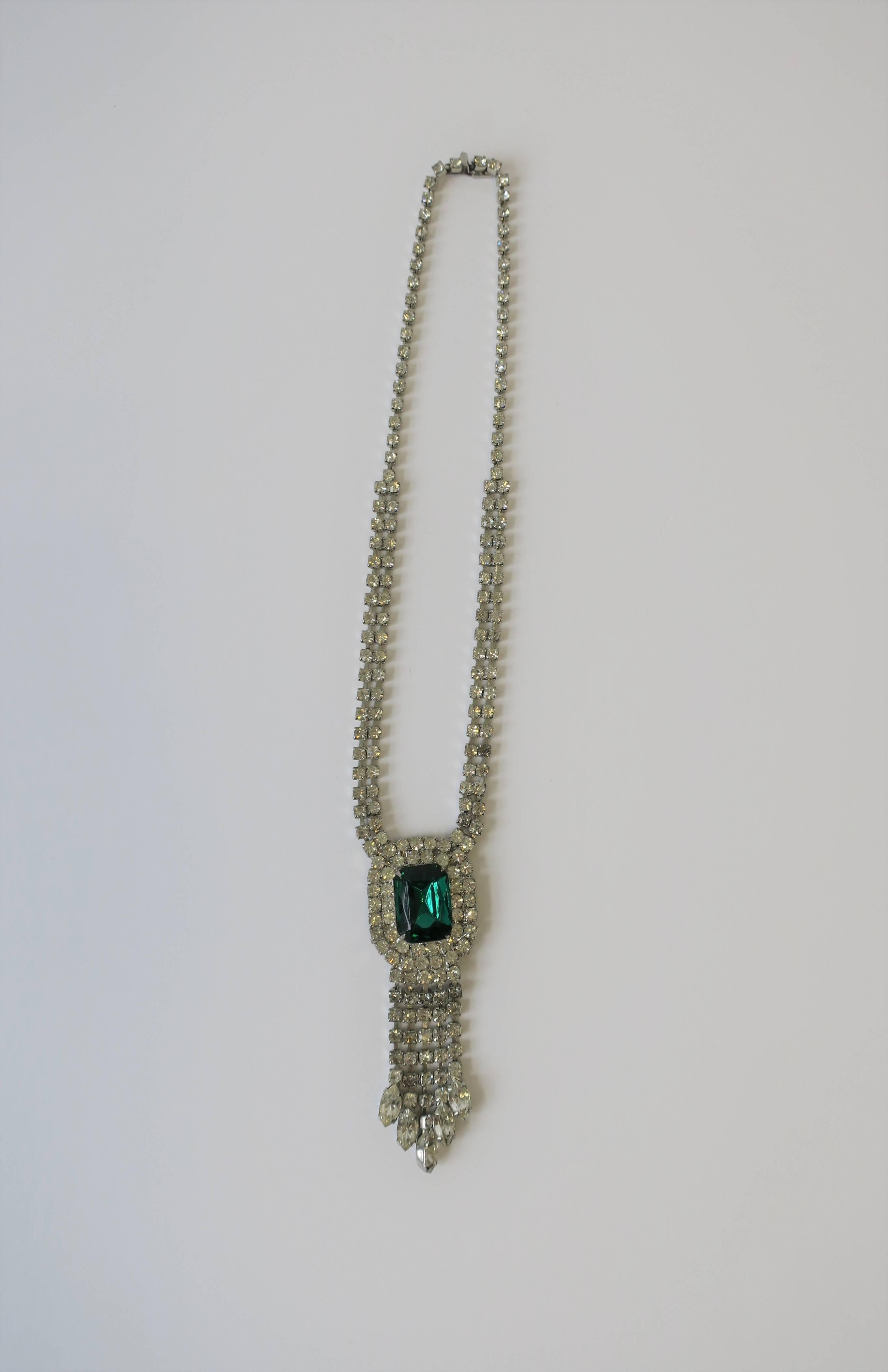 A beautiful vintage green emerald and diamond-esque rhinestone costume jewelry necklace with tassel-like design. Necklace measures, while around neck, 10 inches long, as show in image #3. 

Earrings also available, for more information search