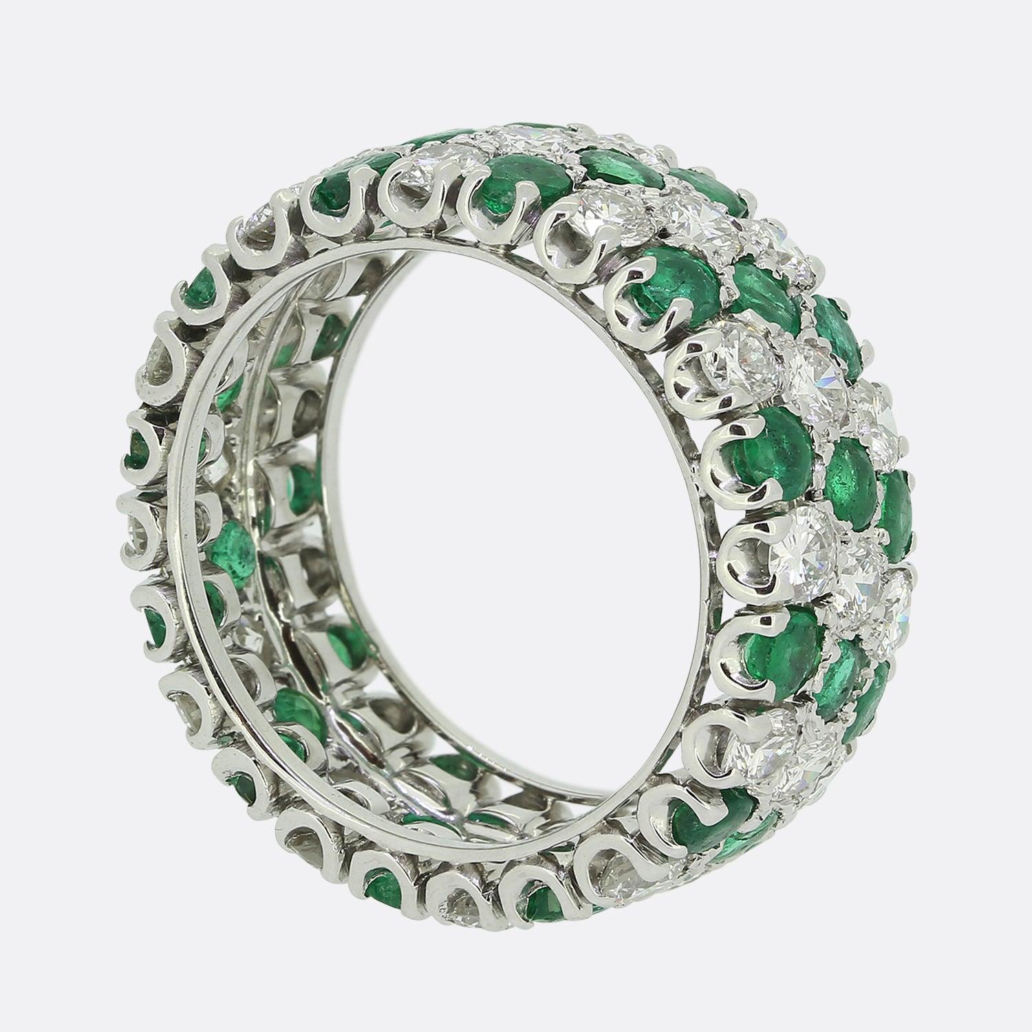 Here we have an excellently crafted emerald and diamond eternity ring. Three rows of alternating gemstones set the tone of the piece with both the emeralds and diamonds falling in groups of three in a vertical sequence. All stones here have been