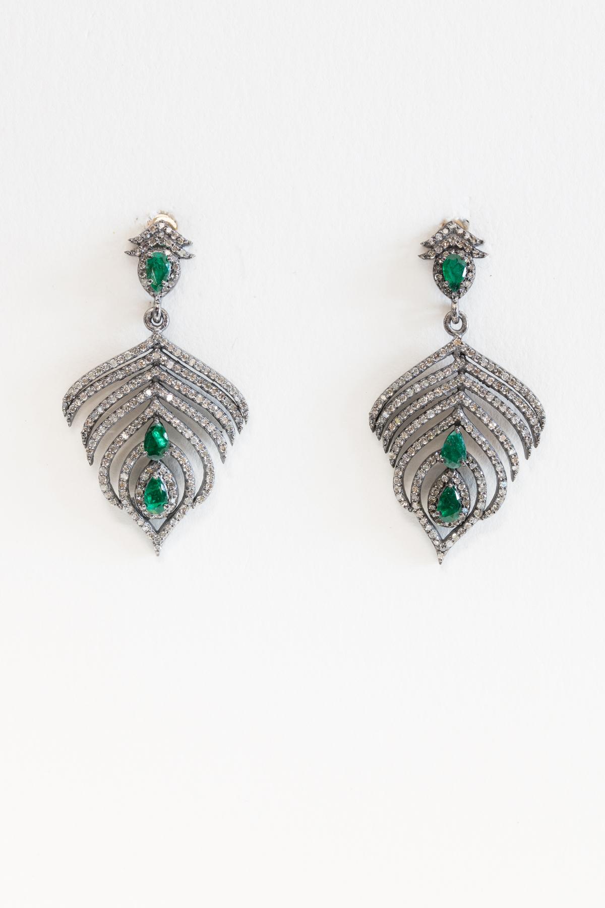 A great twist on the feather earrings...a bit shorter with pave` set diamonds and three faceted, pear-shaped emeralds set in an oxidized sterling silver.  Has an Art Deco feel about them.  Carat weight of diamonds is 1.68; emeralds are 1.39 carats. 