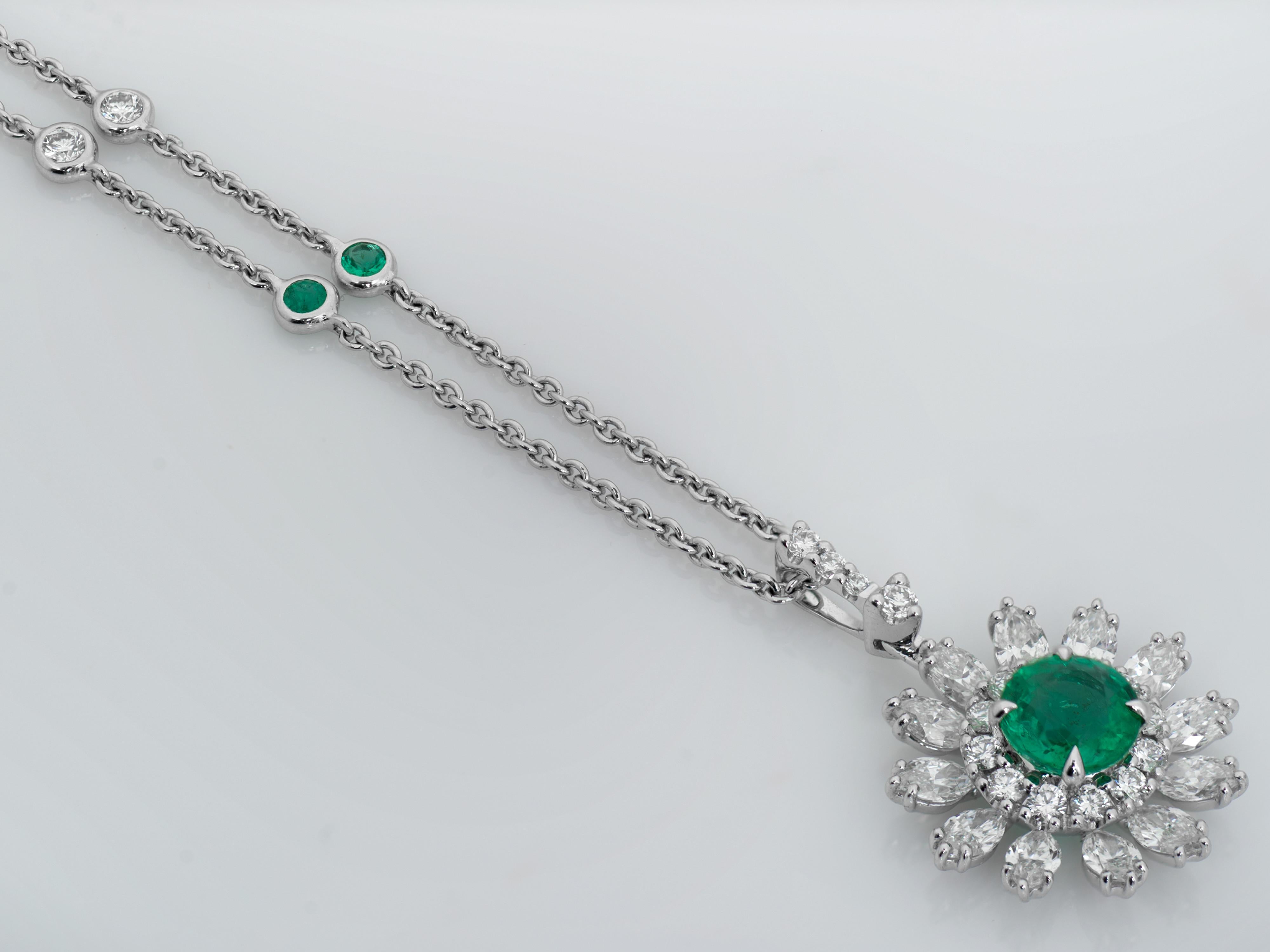 Ladies beautiful diamond and emerald pendant in 18kt white gold. Pendant contains a .94 carat of a round emerald in the centre of the flower, which is surrounded by 12 small round diamonds, as well as 12 oval diamonds set in the form of the flower's