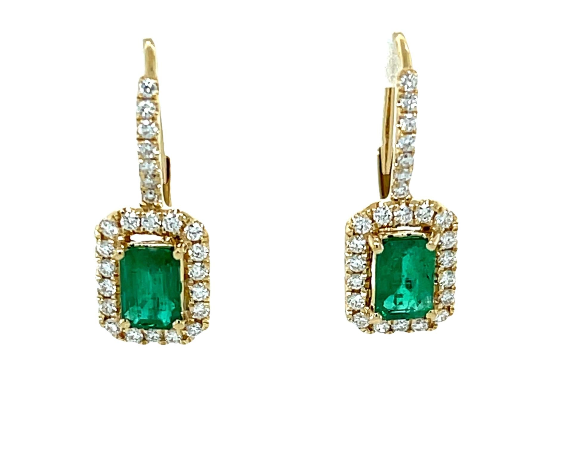 These gorgeous rectangular drop earrings feature a beautifully matched pair of rich, green emeralds framed by a sparkling halo of brilliant white diamonds! The emeralds weigh .98 carat total and are fine quality, clean and a lovely shade of emerald