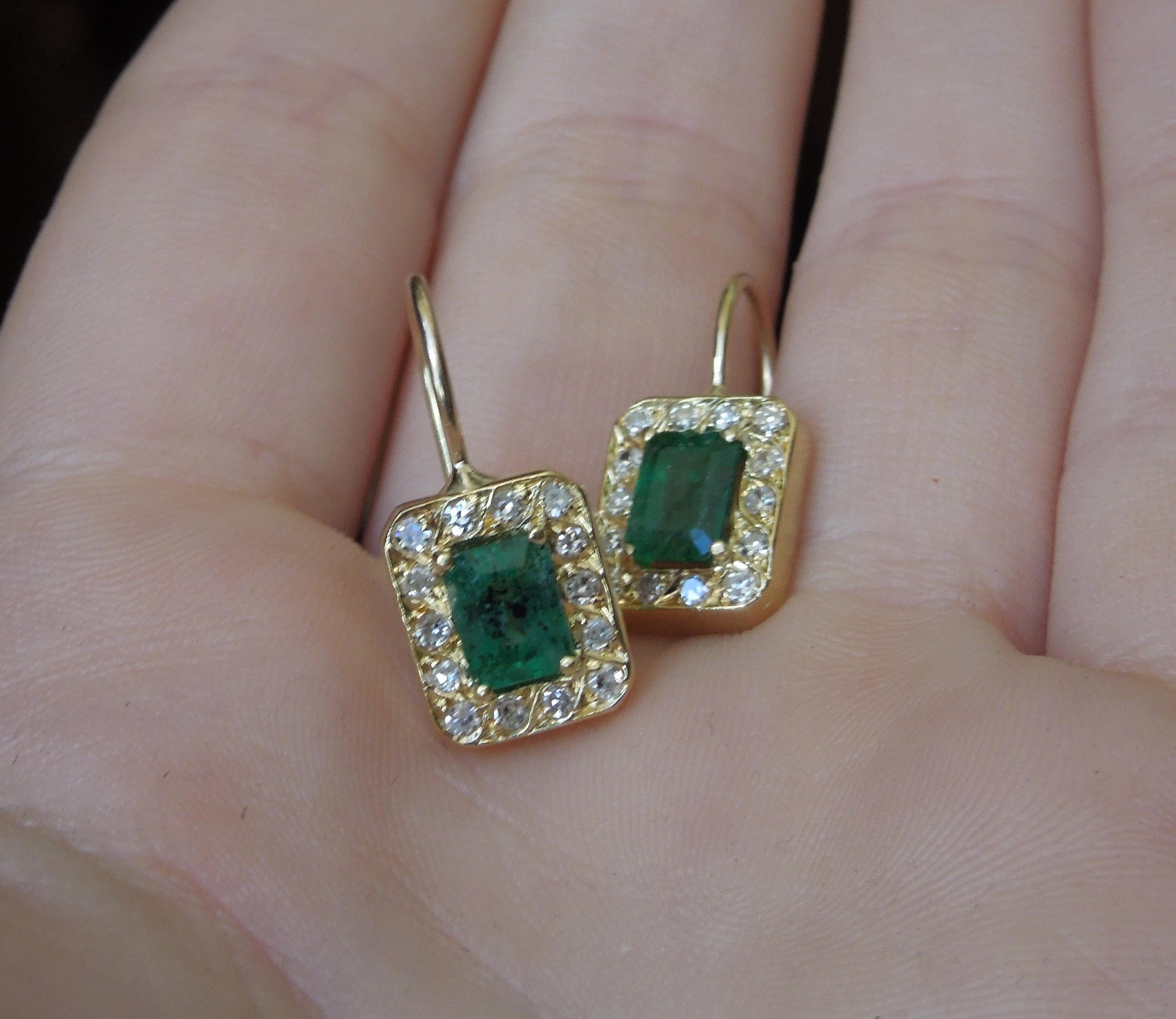 These 14 Karat Gold Emerald & Diamond Halo Earrings feature 2 Central Emerald cut Natural Intense Rich Green Emeralds totaling 2.03 carats. Slightly Opaque, with internal inclusions as well as few coming up to surface (a.k.a. Striation) - Refer to