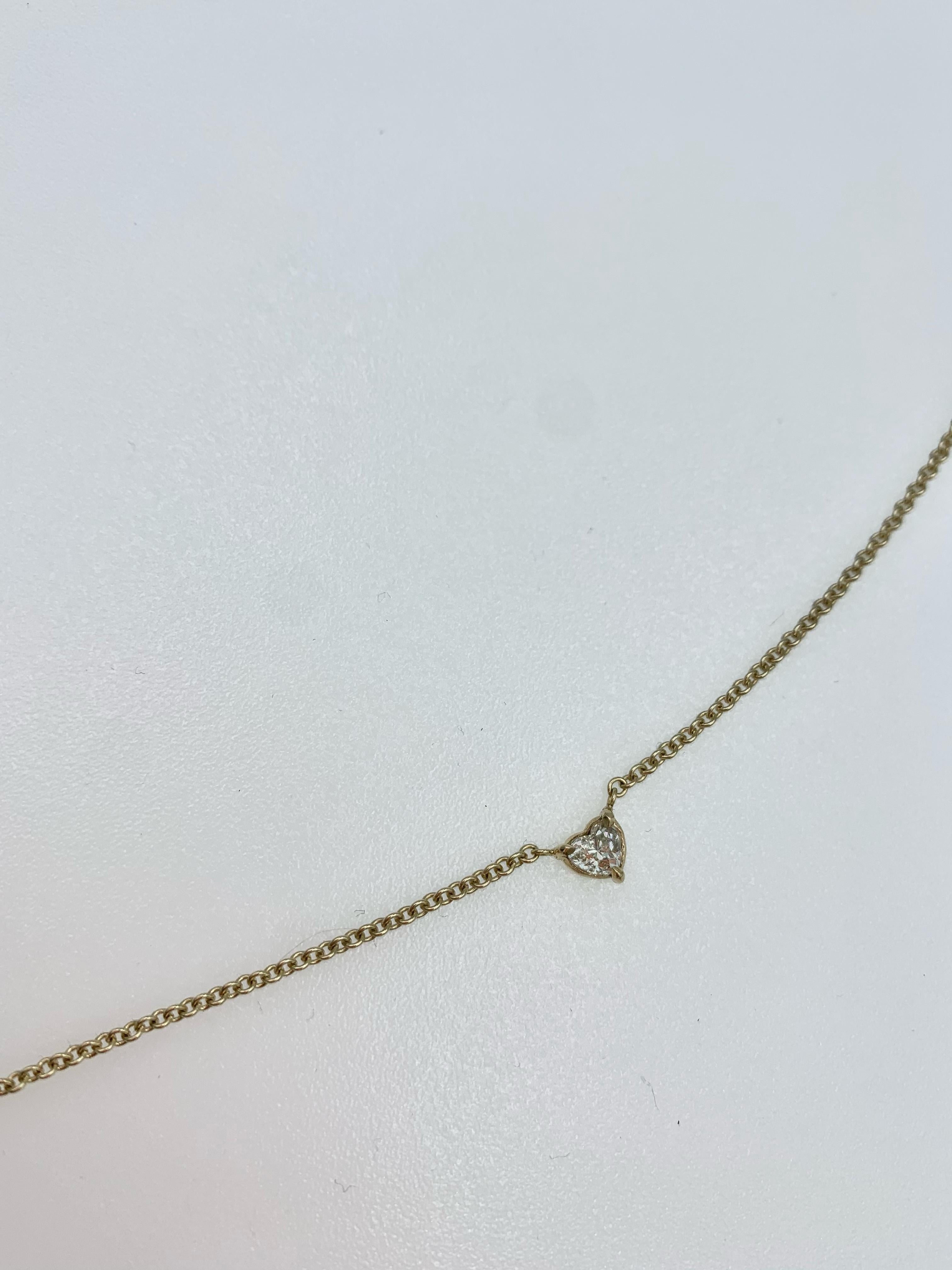 Hand made in 9 karat yellow gold with a heart shaped Emerald in the middle and two heart shaped Diamonds to each side, each Diamond weighs in at .2 carats. This necklace is perfect for everyday but also as an understated accessory to any event. It