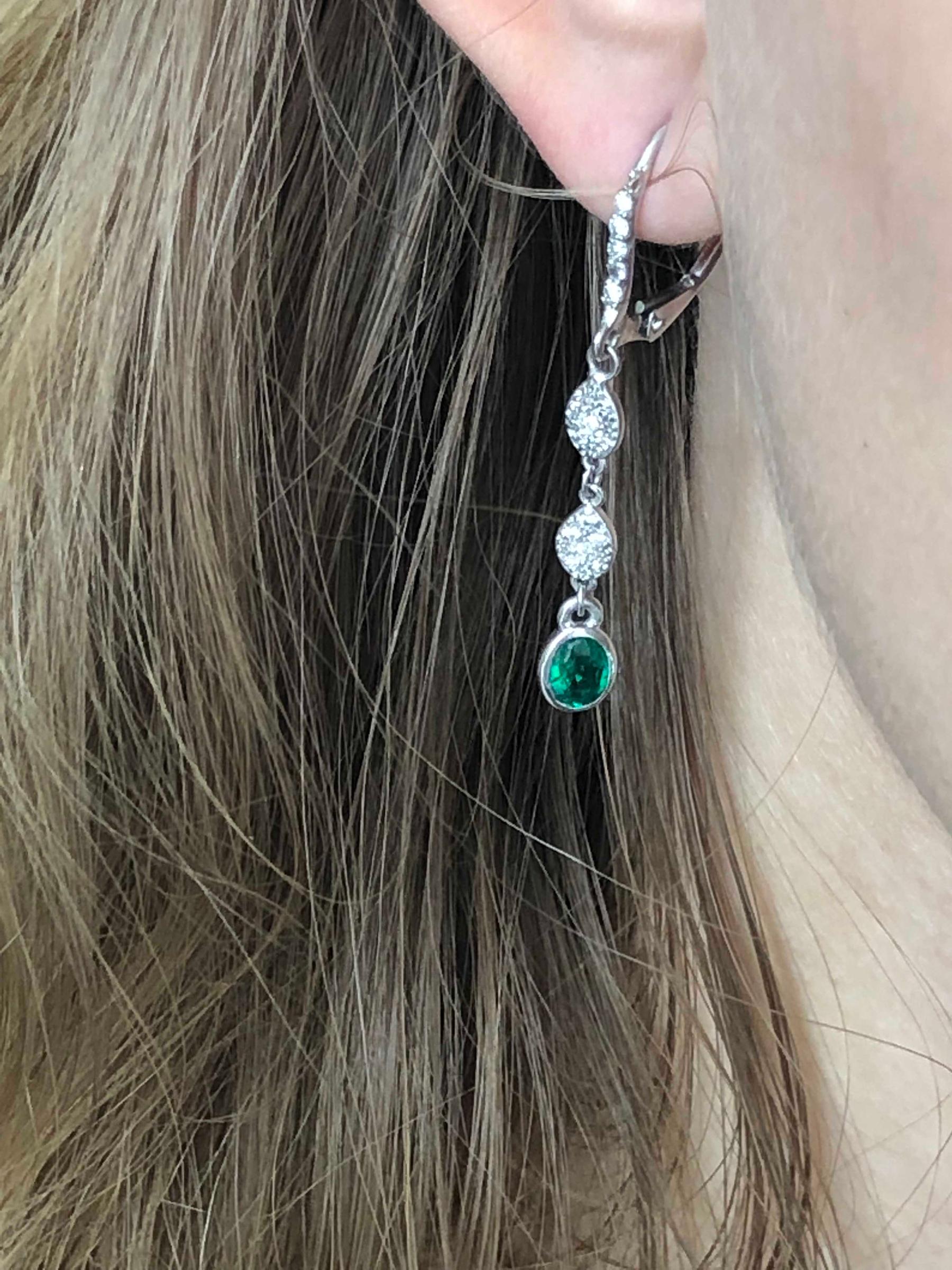 14 karat white gold hoop one and a half inch long drop earrings 
Diamond weighing 0.45 carat
Emeralds weighing 0.95 carat 
New Earrings
Handmade in USA
Our design team select gemstones for their quality, aesthetic beauty and sale value of the