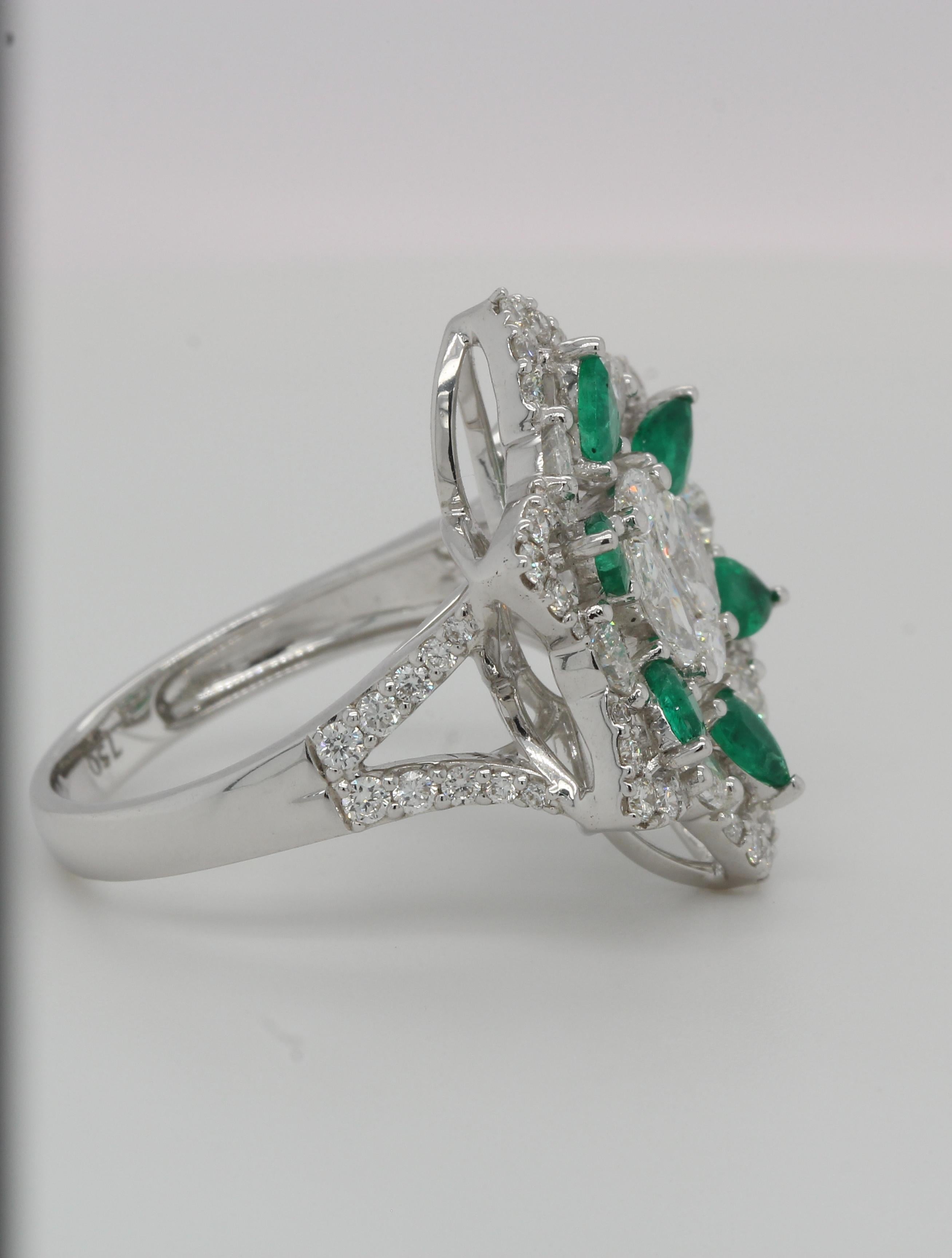 A brand new emerald and diamond ring in 18K gold. By creating an illusion of diamond in the center so it seems to be one piece, and emerald pears weighing 0.74 carats are positioned around it. It has 1.96 carats of diamonds in various shapes. This