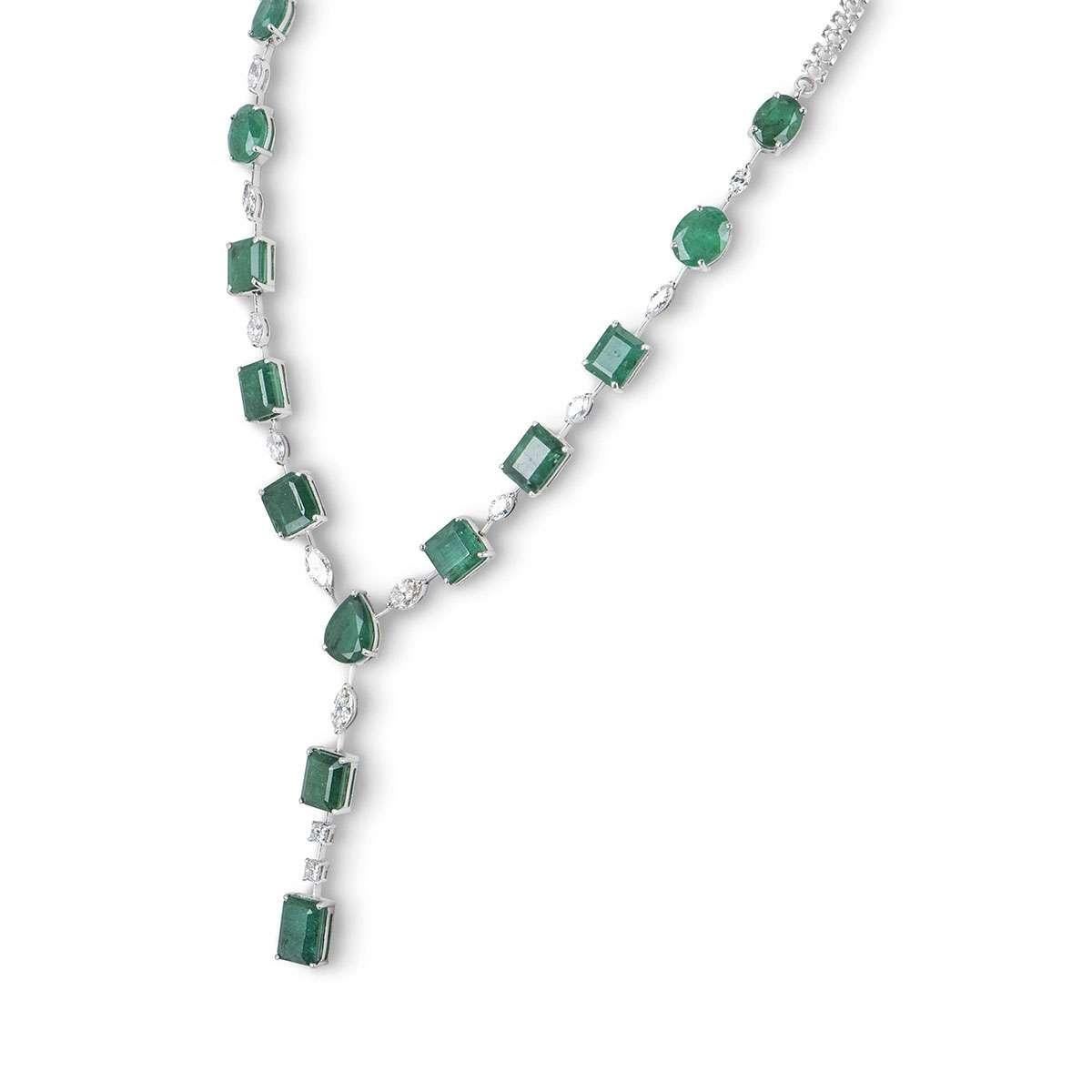 An 18k white gold necklace and earring jewellery suite. The necklace features 13 emeralds in a range of cuts, 11 marquise cut diamonds and 2 princess cut diamonds. The earrings are made up of an oval cut diamond, followed by 2 princess cut diamonds,