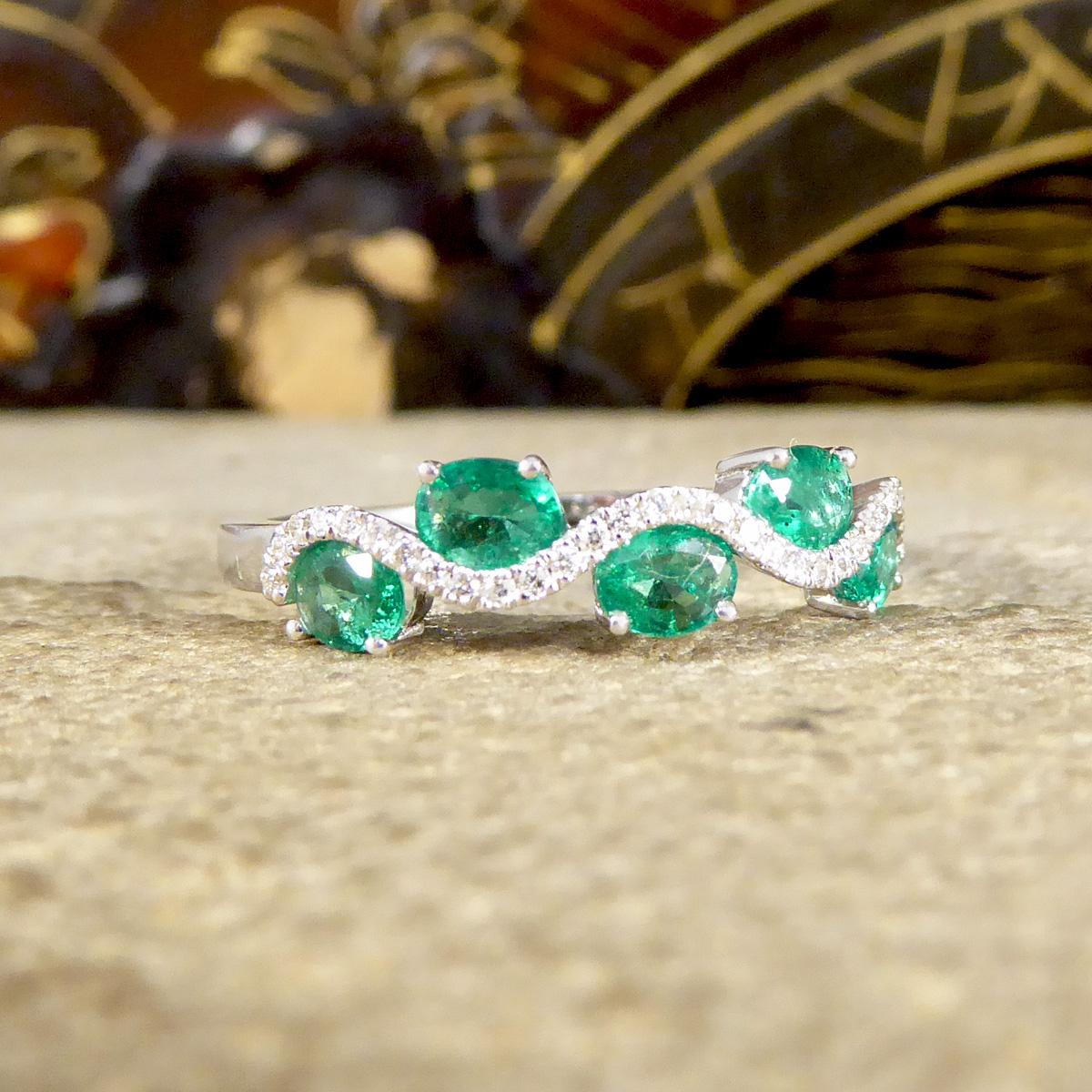 A beautiful half eternity ring with a difference! It sparkles across the whole face of the finger with Oval Cut Emeralds weighing a total of 0.65ct, each stone is alternating on either side of the head of the ring with smaller Diamonds weaving