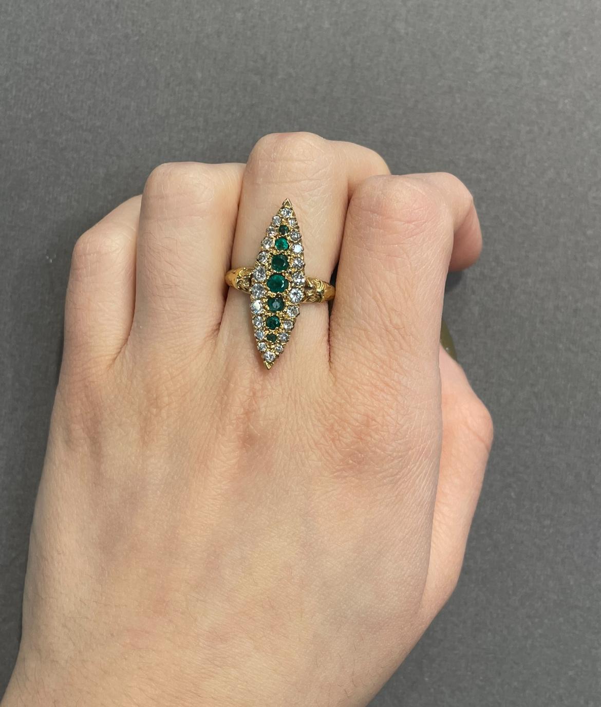 Emerald and Diamond Navette Ring 

A yellow gold navette ring set with round cut emerald and diamonds. 

Approximate Emerald Weight: 1 carat
Approximate Diamond Weight: .88 carats
Ring Size: 8.5
Complimentary resizing 
