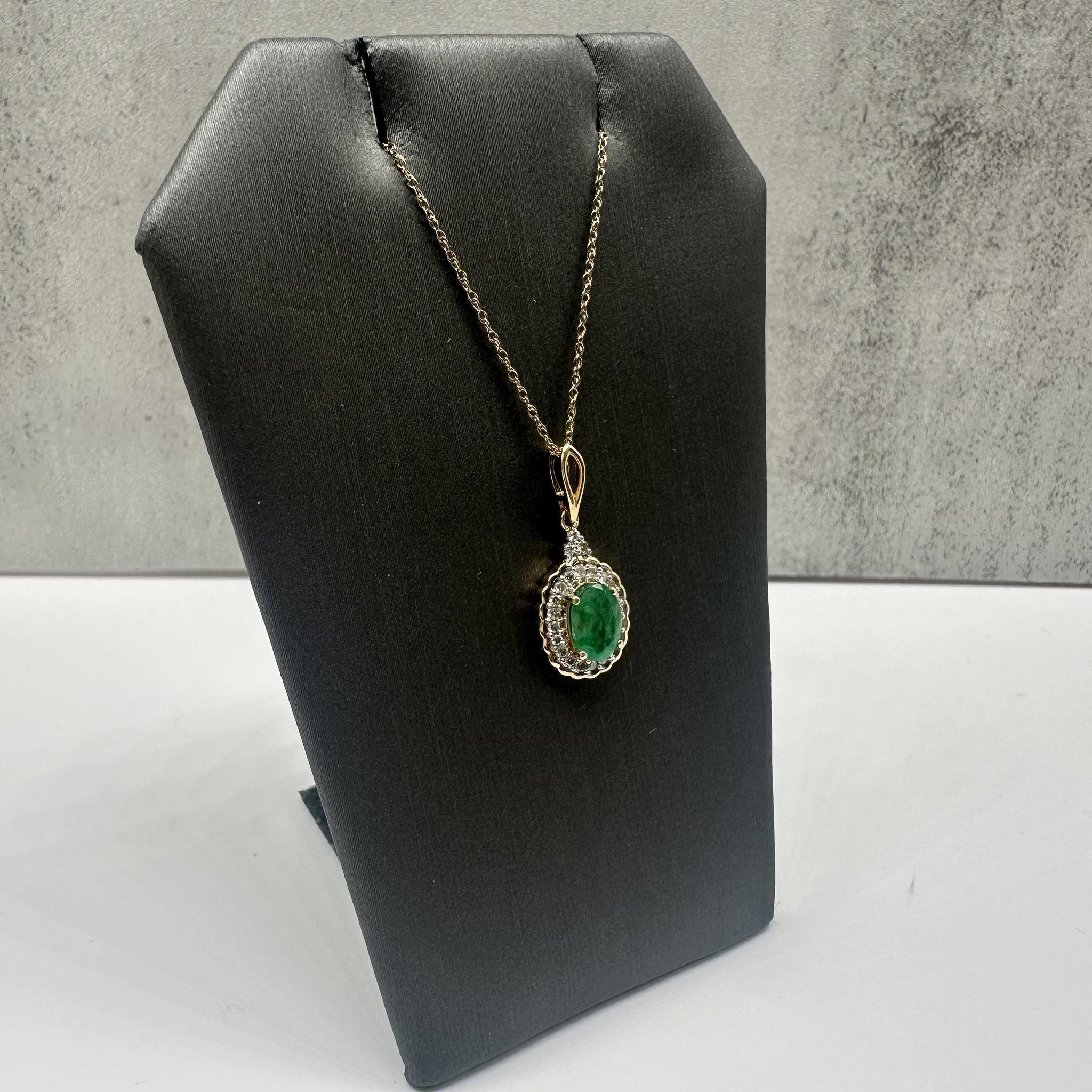 This elegant Emerald and Diamond Necklace in 10kt yellow gold features a stunning 6.8x5mm oval emerald, complemented by 0.18ctw of natural GH SI2-I1 round diamonds. The 18-inch length fits comfortably around the neck, and the spring ring clasp
