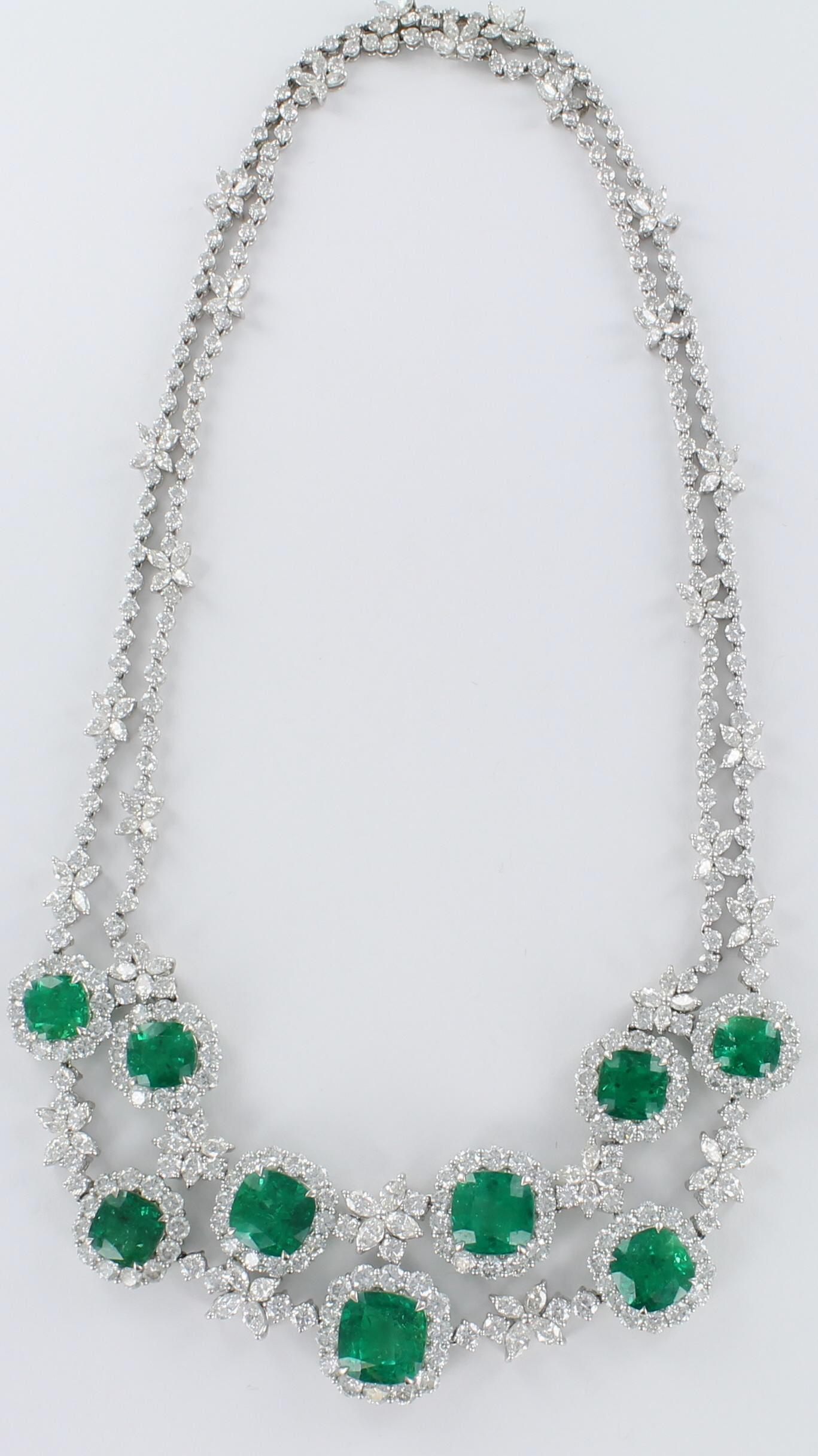 This is a sensational 18 karat white gold necklace featuring emeralds and diamonds designed as a double strand.  There are nine cushion-cut emeralds totaling 31.70 carats and 20.00 carats total weight of round and marquise diamonds.  The emeralds