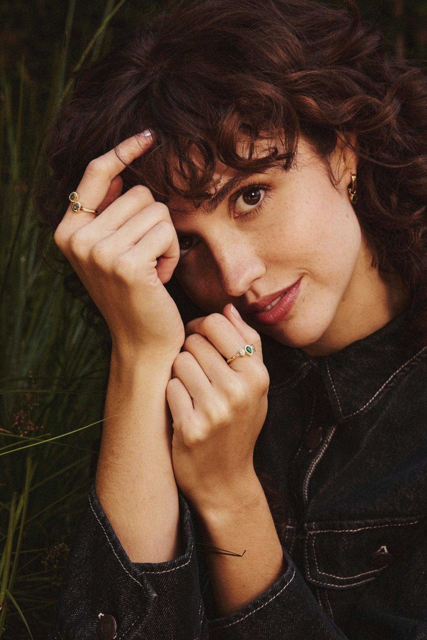 Questo splendido anello a tre pietre è caratterizzato da una pietra centrale, una pera di smeraldo di 6x4 mm incastonata nel castone, pari a 0,33 carati. Le due pietre laterali sono diamanti a forma di pera incastonati 4x2,4 mm, per un totale di 0,5