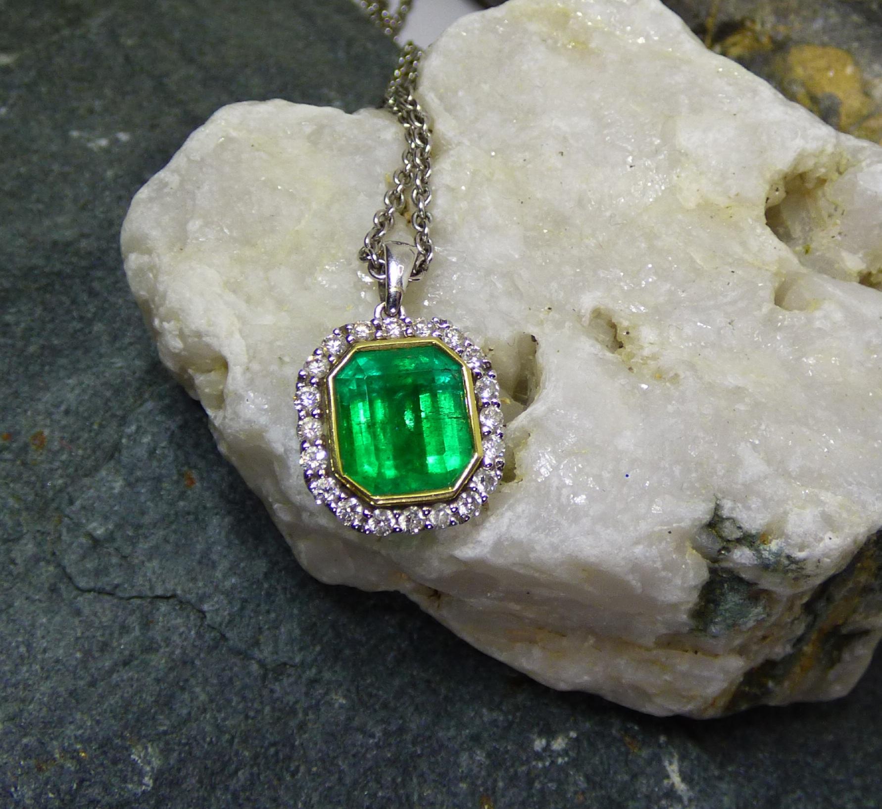 A colourful 10X9mm Step cut Emerald (4.28ct) sets off this pendant. The Emerald is surrounded by 20 Diamonds (.64ct). The total size of the pendant is 15X15mm and handmade  18K white gold with the Emerald bezel set in 18K yellow gold. It is