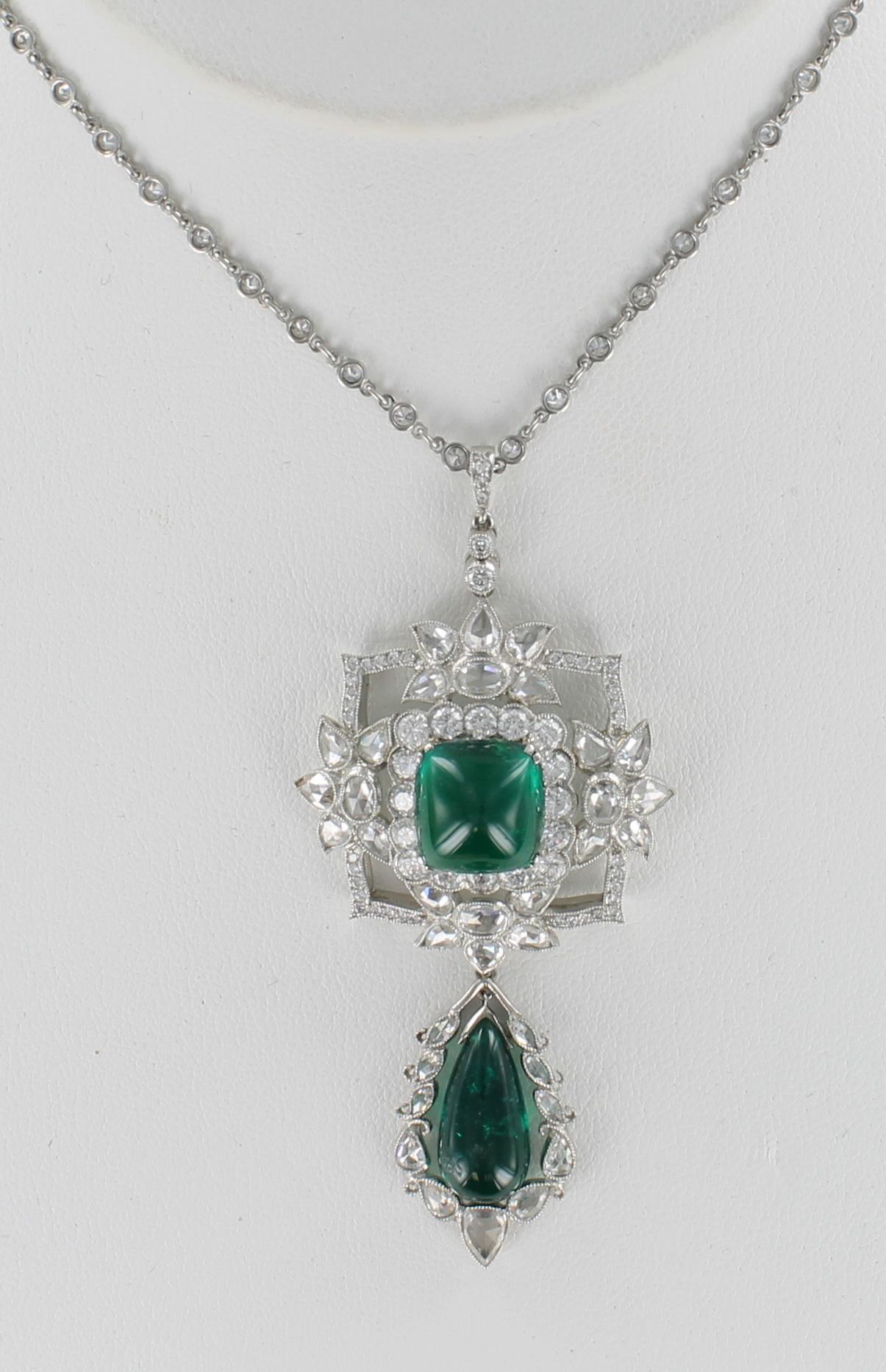 This luxurious pendant features two magnificent cabochon emeralds, 11.5 carats total weight.  The emerald on the top is a cushion cut, and the pear-shaped emerald sways gently at the bottom.  3.50 carats total weight of rose cut diamonds and 1.40