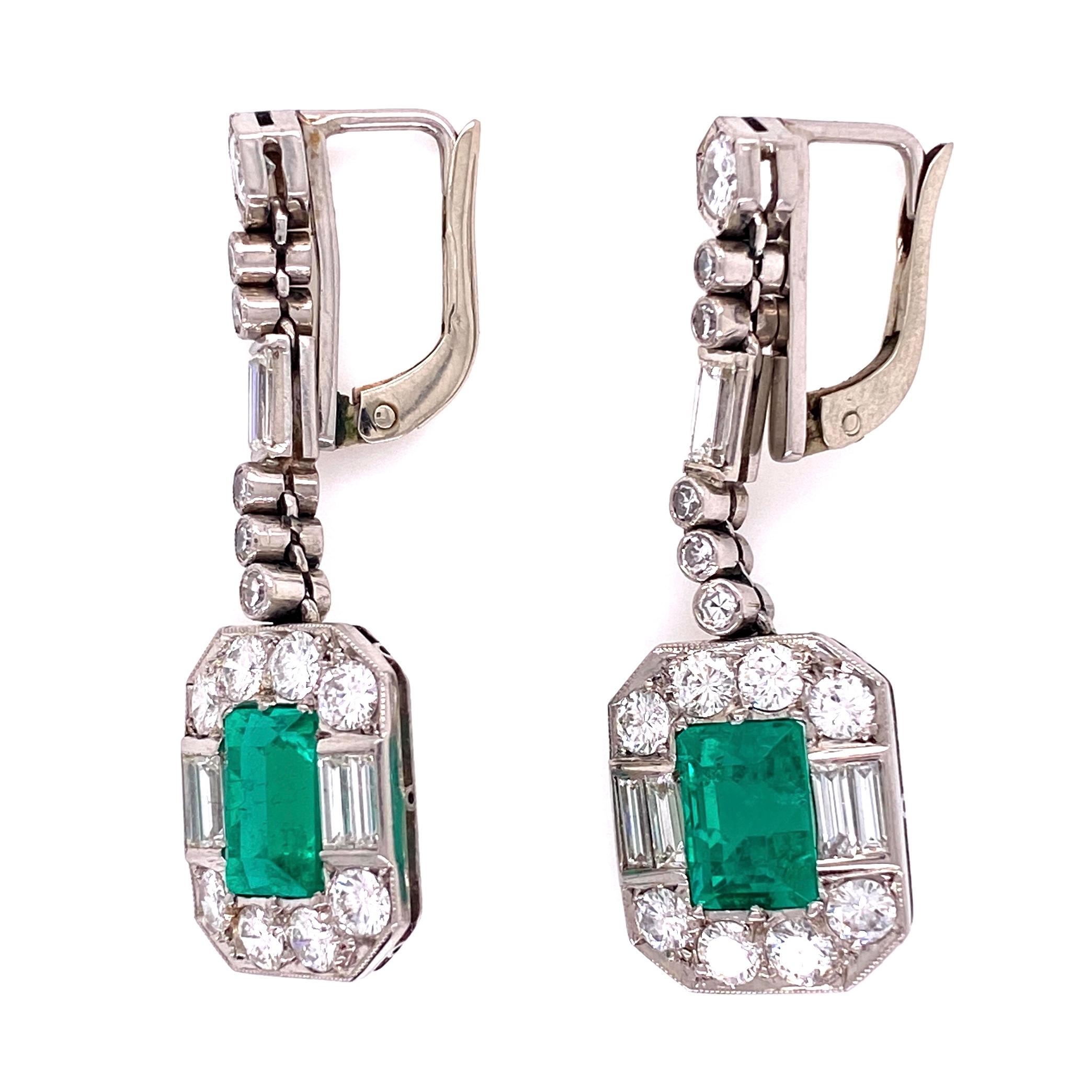Beautiful, Elegant & finely detailed Cluster Dangle Earrings set with Green Columbian Emerald Gemstones, approx. total weight of the 2 Emeralds 4.00 Carats and enhanced with Diamonds, approx. total weight 3.00 Carats. Lever back earrings measure