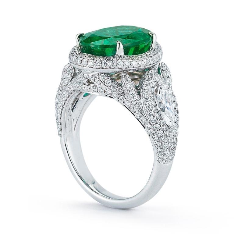 EMERALD AND DIAMOND RING Marquis and round shaped diamonds swirl around a beautiful Oval cut emerald to give this piece a dramatic look Item: # 01927 Metal: 18k W Lab: Gia Color Weight: 5.18 ct. Diamond Weight: 2.39 ct.
