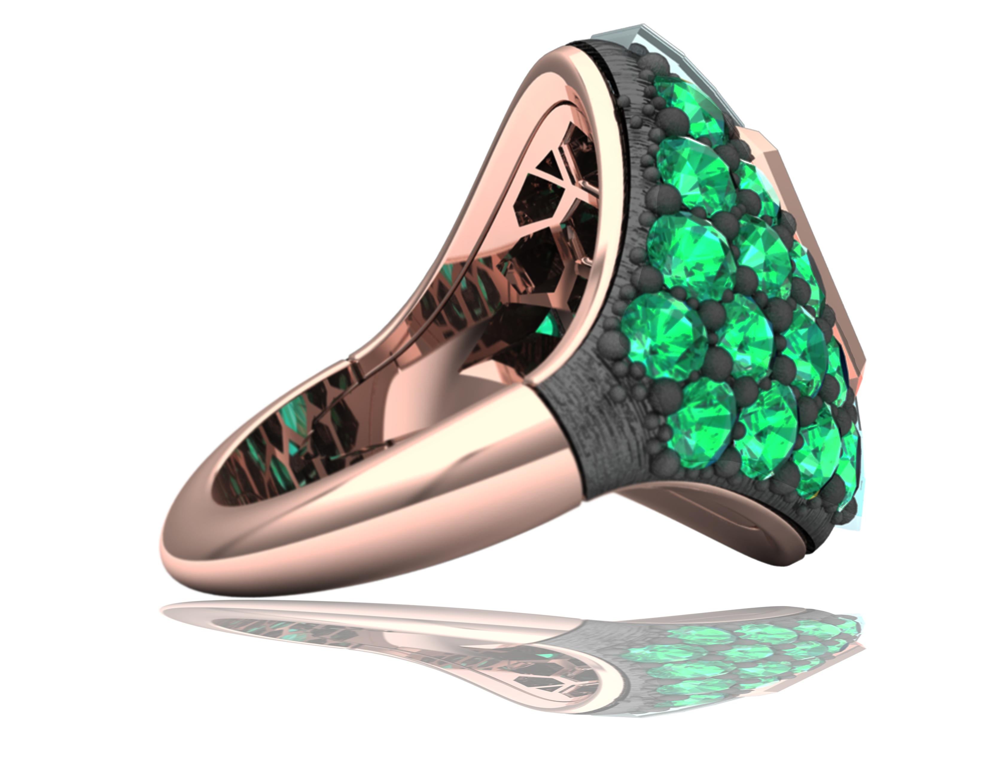 A green tapestry of gorgeous emeralds in varying sizes, shades, and brilliance, this ring has a radiant cut Emerald centered, which is light greenish-blue in color and bezel set in rose gold.  The center stone has over 2 carats of rich green