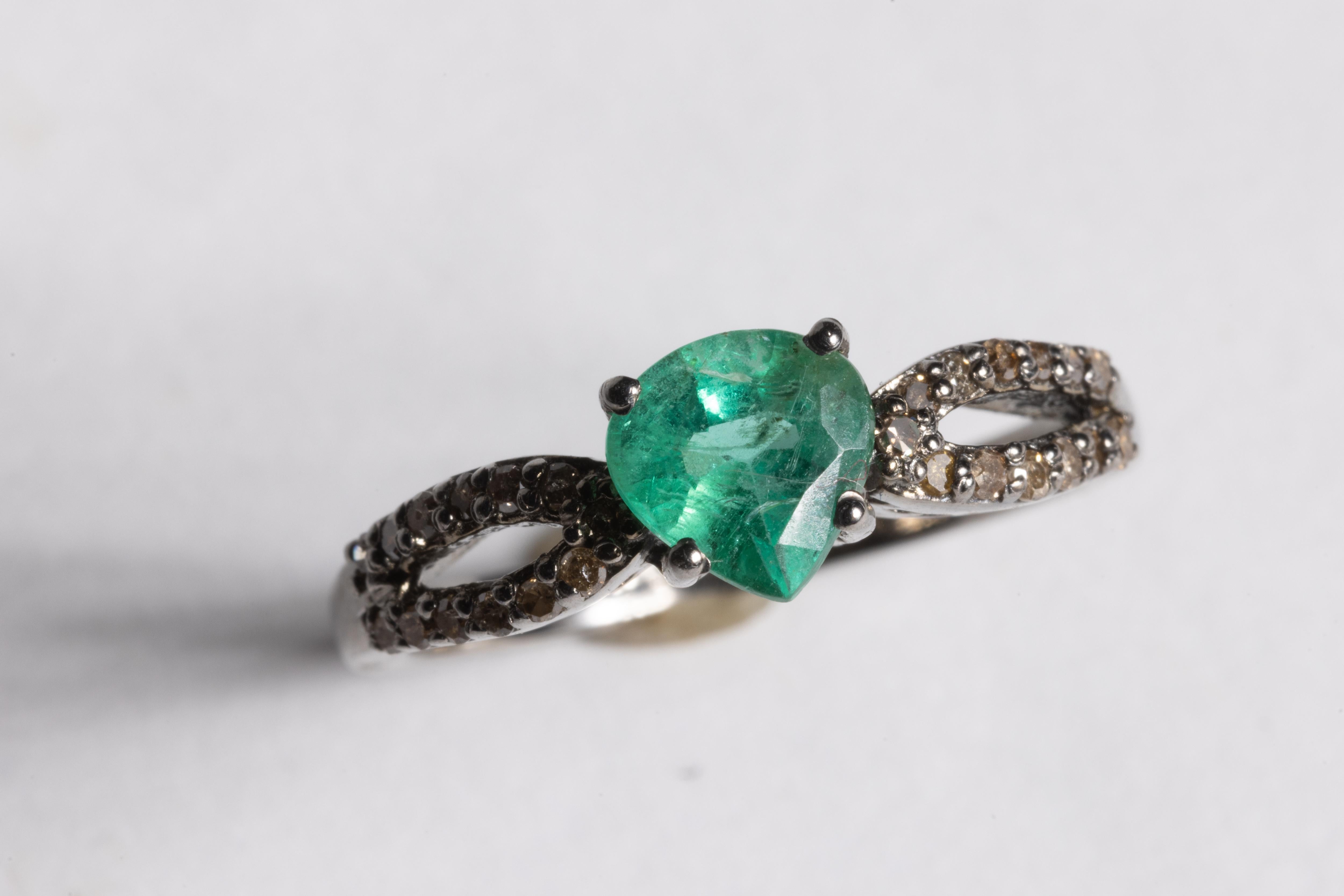 Ein wunderschöner facettierter, birnenförmiger kolumbianischer Smaragd steht in der Mitte dieses Rings.  Der Ring ist aus oxidiertem Sterlingsilber gefertigt und mit einer doppelten Reihe runder Diamanten im Brillantschliff besetzt.  Der Smaragd hat