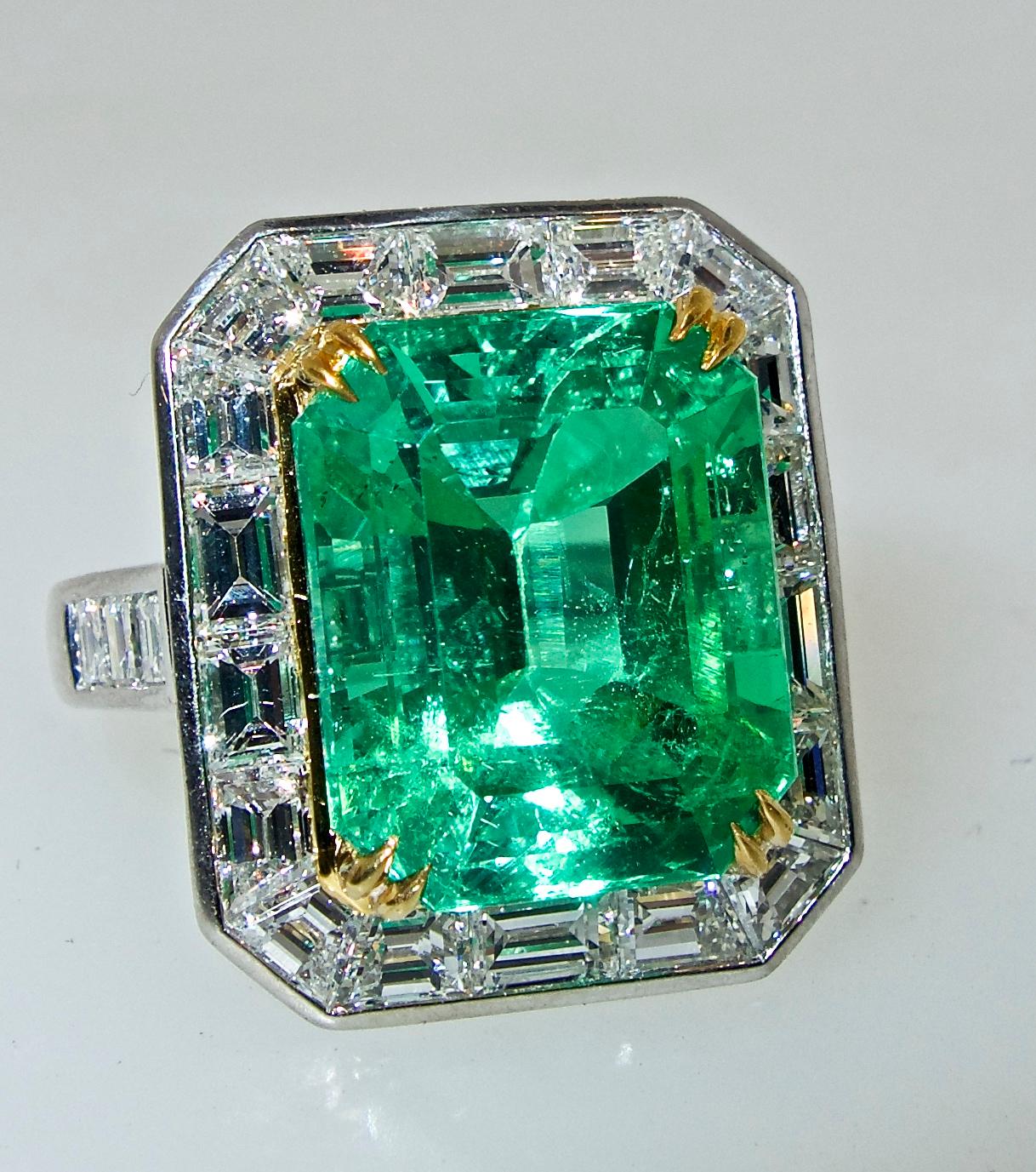 Colombian emerald, probably from the old Chivor mines, this medium bright color natural fine emerald is surrounded by fine white diamonds, G/H color and very slightly included.  The emerald weighs 8 cts.  The diamonds weigh 2.74 cts.  The platinum