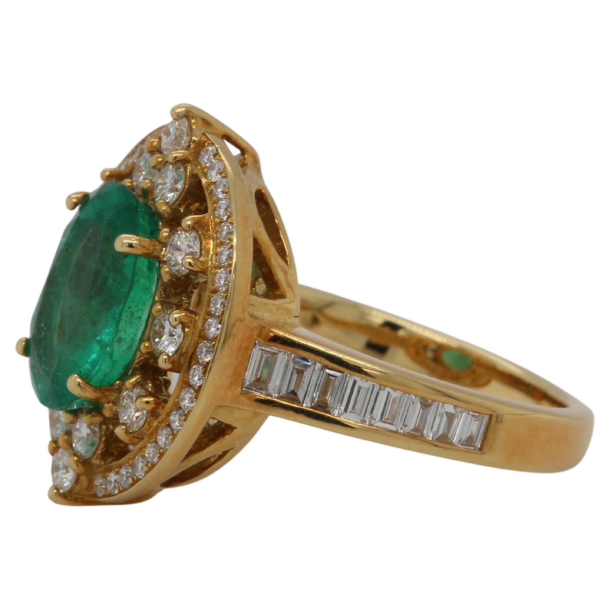 A brand new emerald and diamond 18K gold ring. A 2.29 carat emerald oval shape is set in this ring, which also includes a 0.34 carat diamond tapper and a 0.61 carat diamond round. This ring weighs 8.58 grams and is composed of 18K yellow