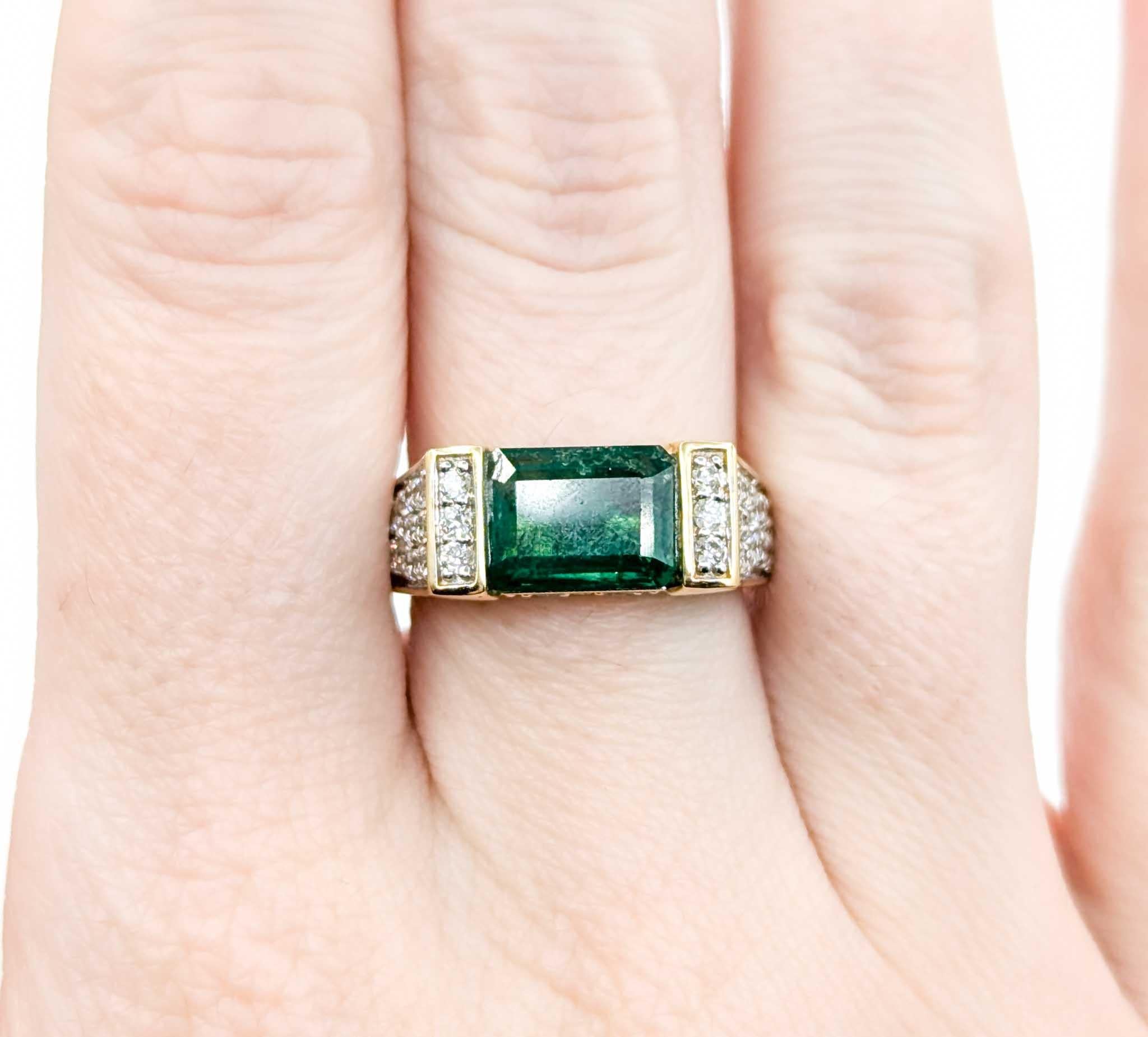 Stunning Emerald and Diamond Ring in 18k Yellow Gold

Introducing this beautiful emerald ring, crafted in 18k yellow gold. The ring features a 2.68ct emerald centerpiece with .96ctw round diamonds and bar set gems, creating a striking and elegant