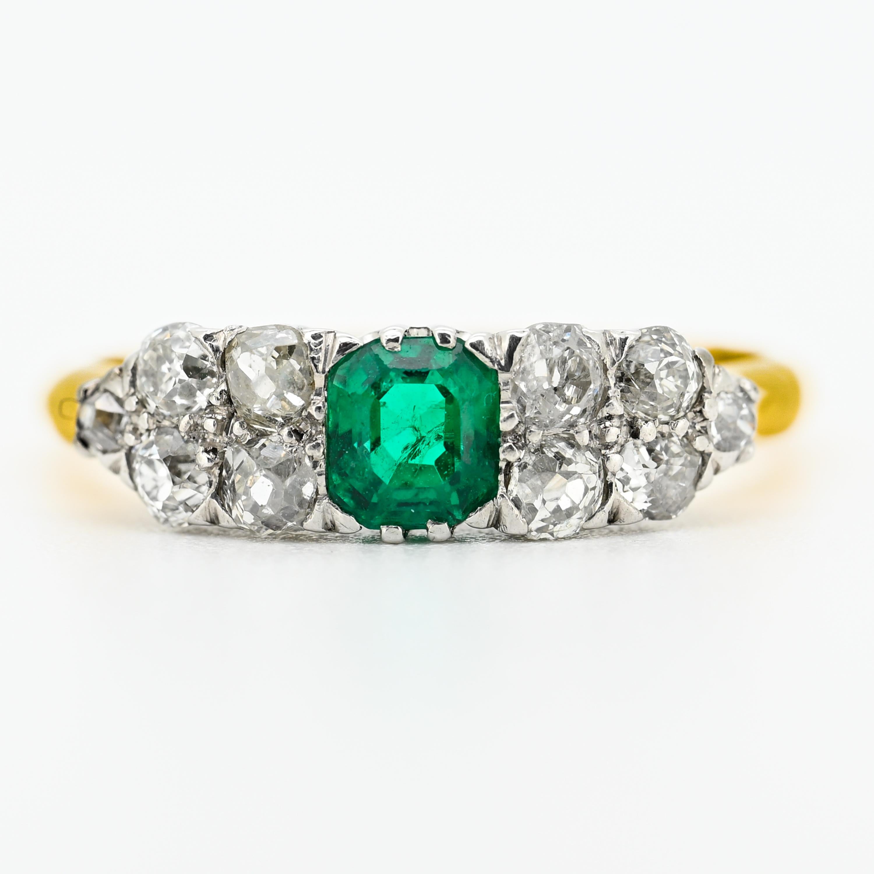 Chef-d'œuvre de l'époque de l'Arte Antiques, cette extraordinaire bague réunit une radieuse émeraude de 0,65 carat, d'un vert électrique lumineux, à une étincelante constellation de diamants taillés à l'ancienne. L'émeraude centrale - d'une