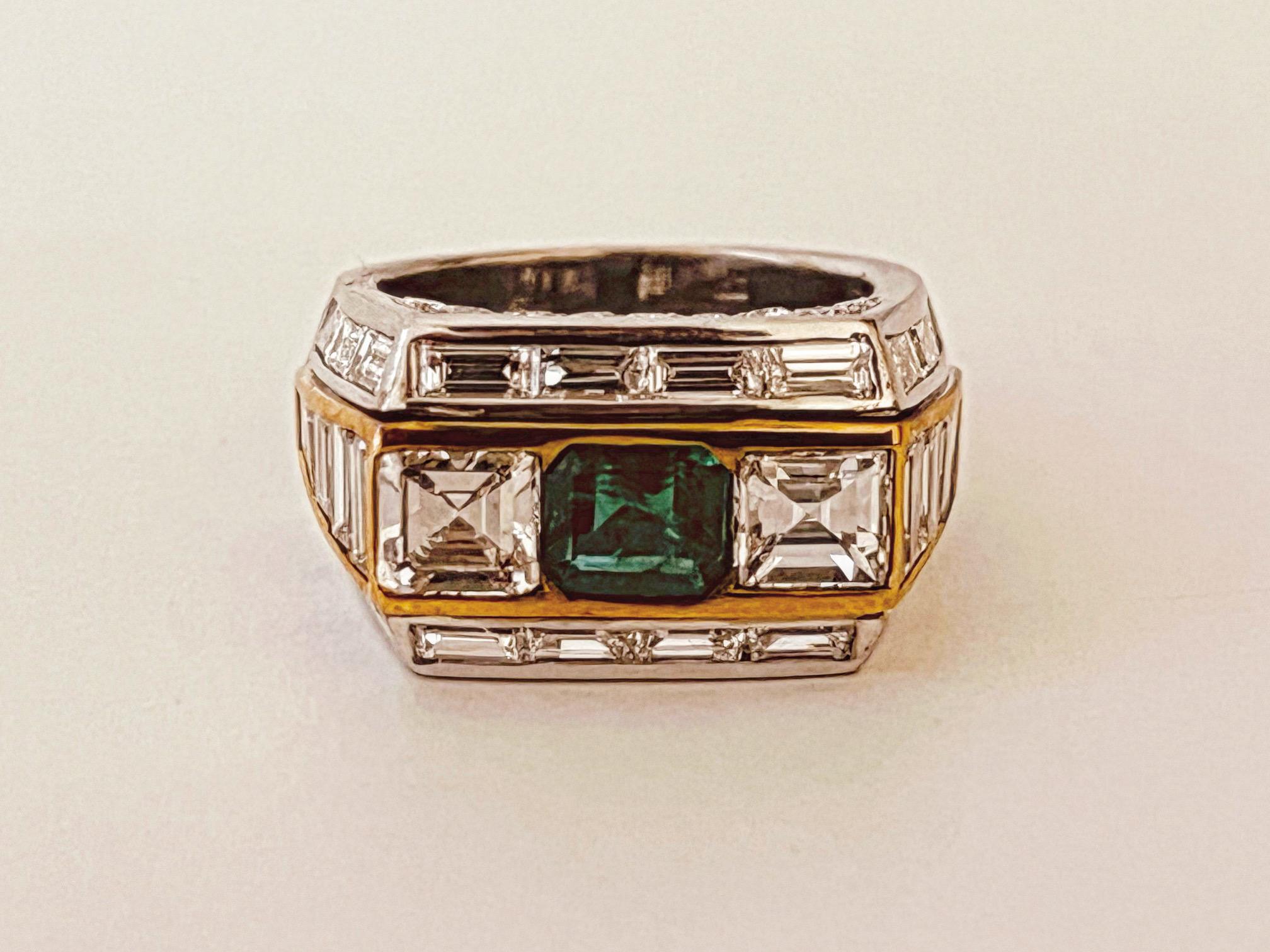 Emerald and Diamond ring. The central  section mounted with an emerald and flanked by two emerald cut diamonds of 1.6cts. The square shaped sides with graduating baguette shoulders. The whole outlined with a row of baguette diamonds. Emerald