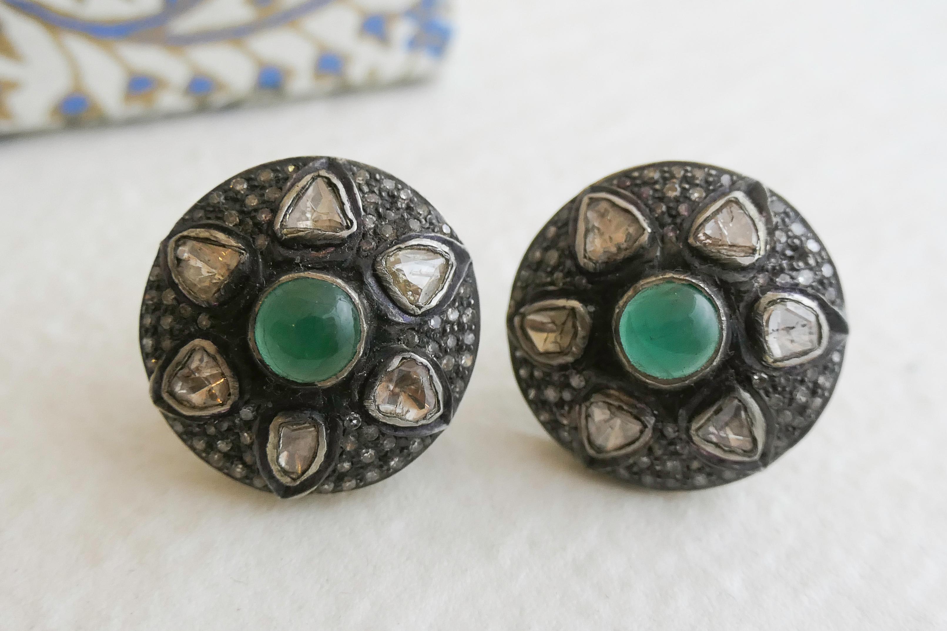 6mm cabochon emeralds are bezel set in oxidized sterling silver.  There are 6 diamond slices with approximate size of 4mm surrounding the emerald.  Pave diamonds are set around the stones.  All metal is sterling silver. 

Diameter of earrings are