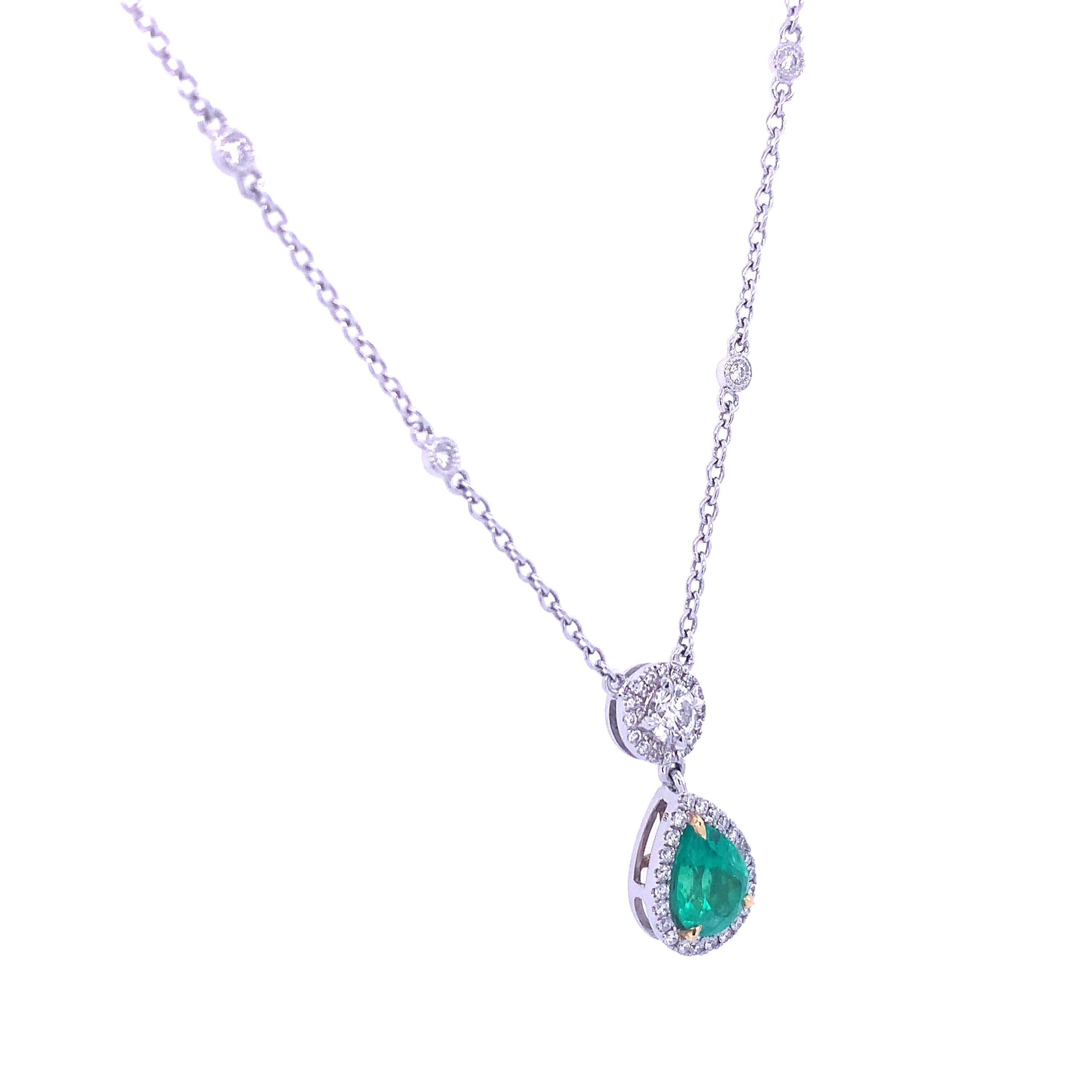 This dazzling diamond and pear-shape emerald drop pendant features a .53 carat diamond drop halo embellished with ten (10) bezel-set diamonds that lead to a 1.24 carat pear-shaped emerald complimented by pave diamonds. This stunning 18K white gold