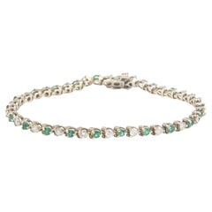 Bracciale tennis in oro bianco con smeraldo e diamanti